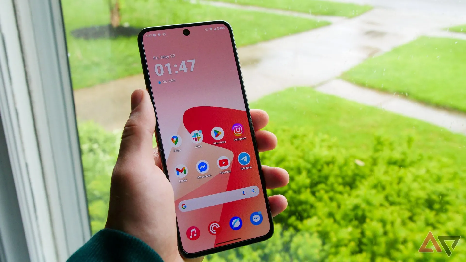 Điện thoại Motorola Razr Ultra 2025 đang gập, được cầm trên tay cạnh cửa sổ, minh họa thiết kế nhỏ gọn