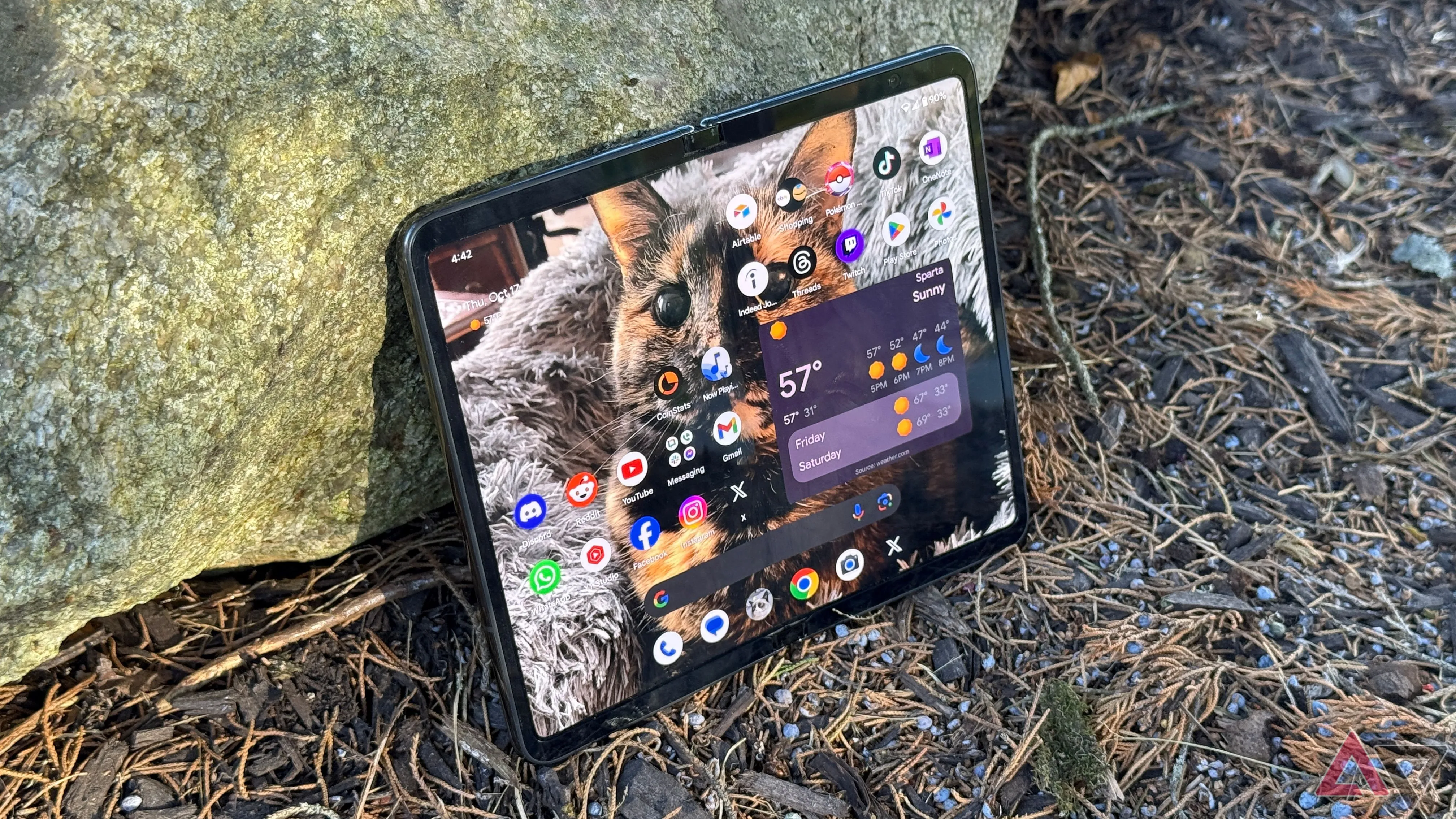 Google Pixel Fold đặt nghiêng dựa vào đá ngoài trời