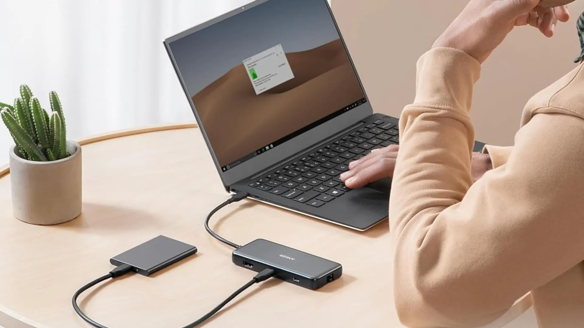 Hình ảnh minh họa hub USB-C Anker 555 8-in-1 đặt trên bàn cắm vào laptop.
