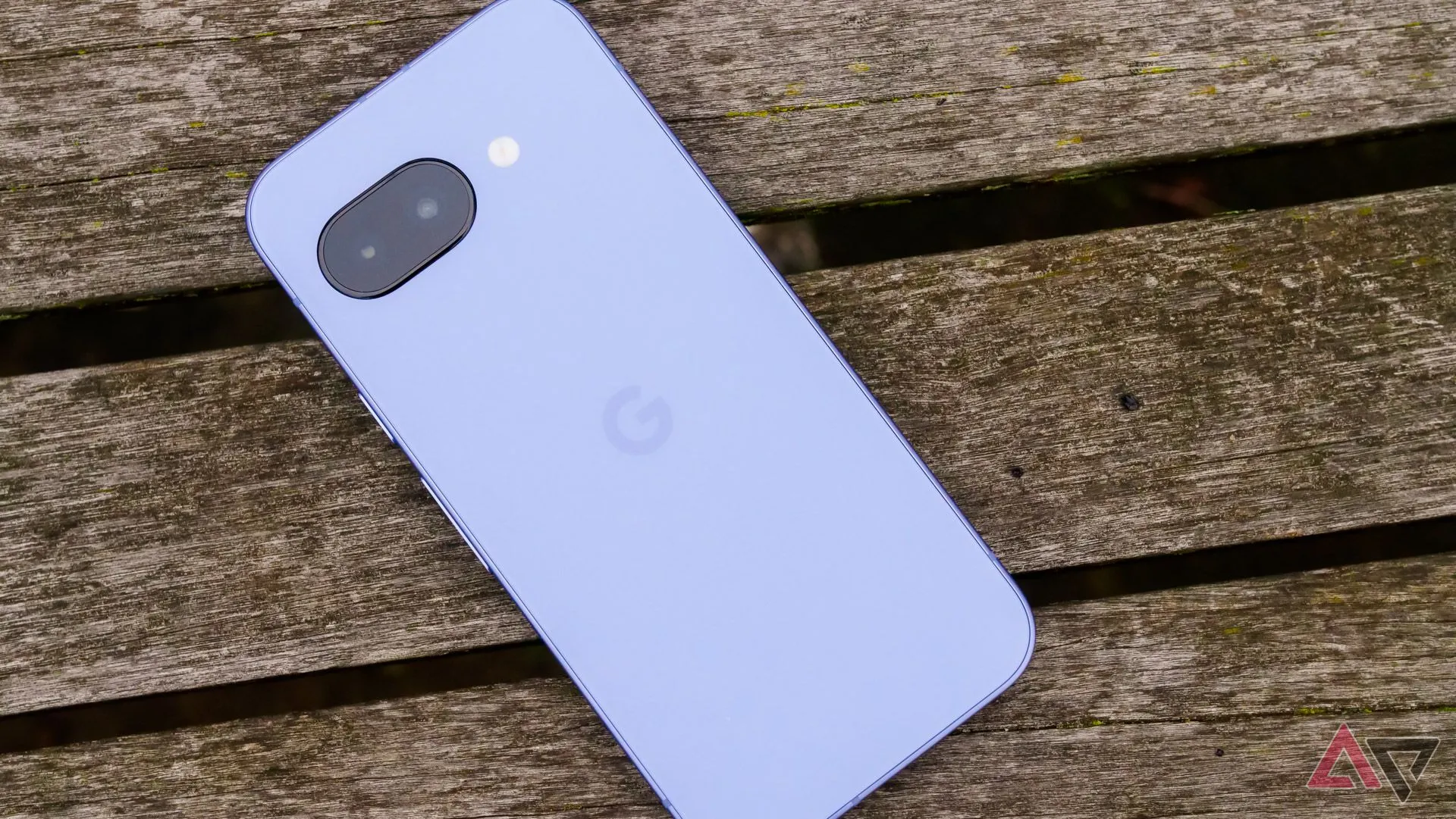 Mặt lưng điện thoại Pixel 9a màu tím đặt úp trên ghế gỗ