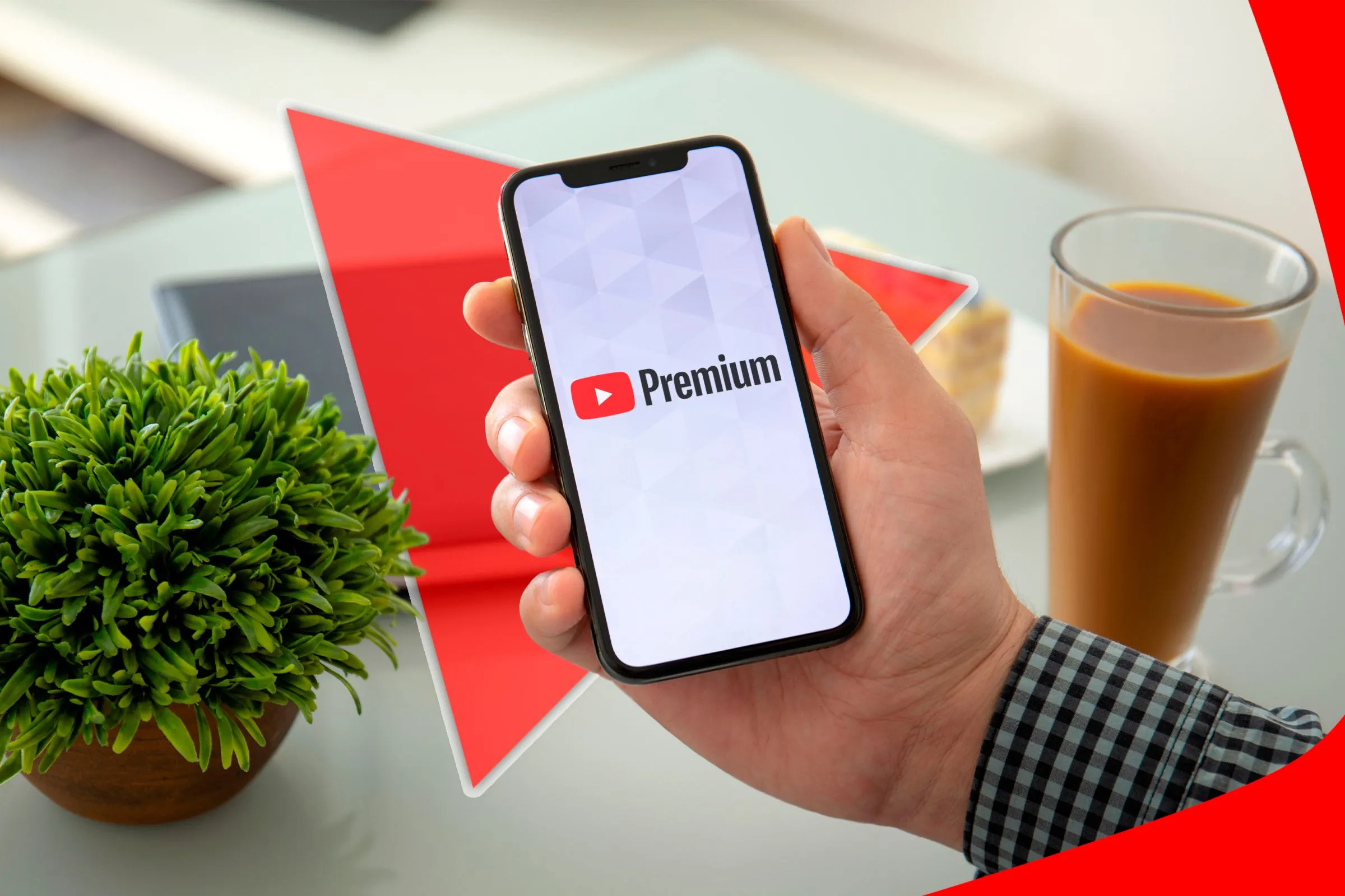 Một bàn tay đang cầm điện thoại với logo Youtube Premium trên màn hình.