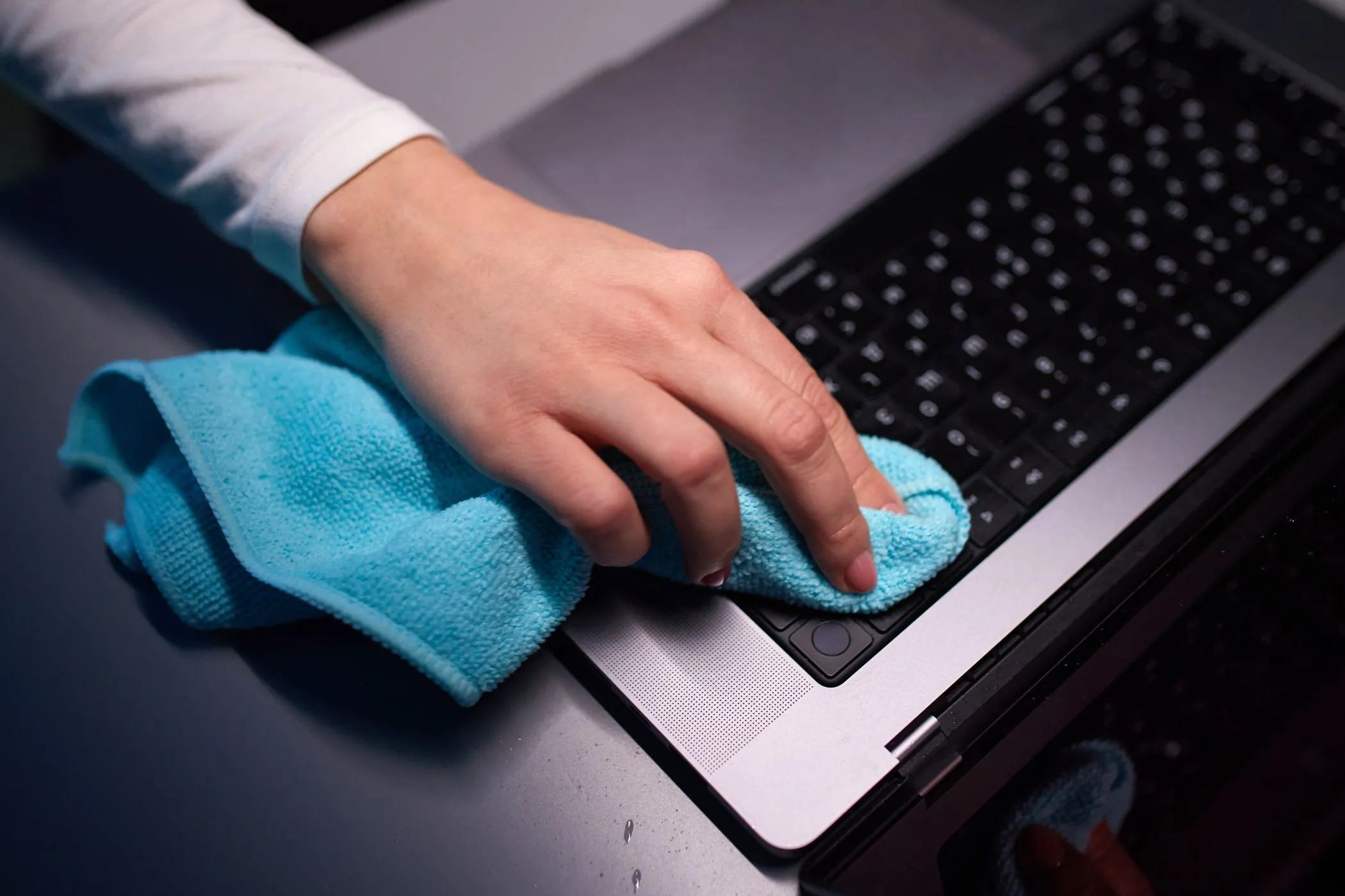 Người dùng đang vệ sinh màn hình MacBook Pro bằng khăn microfiber