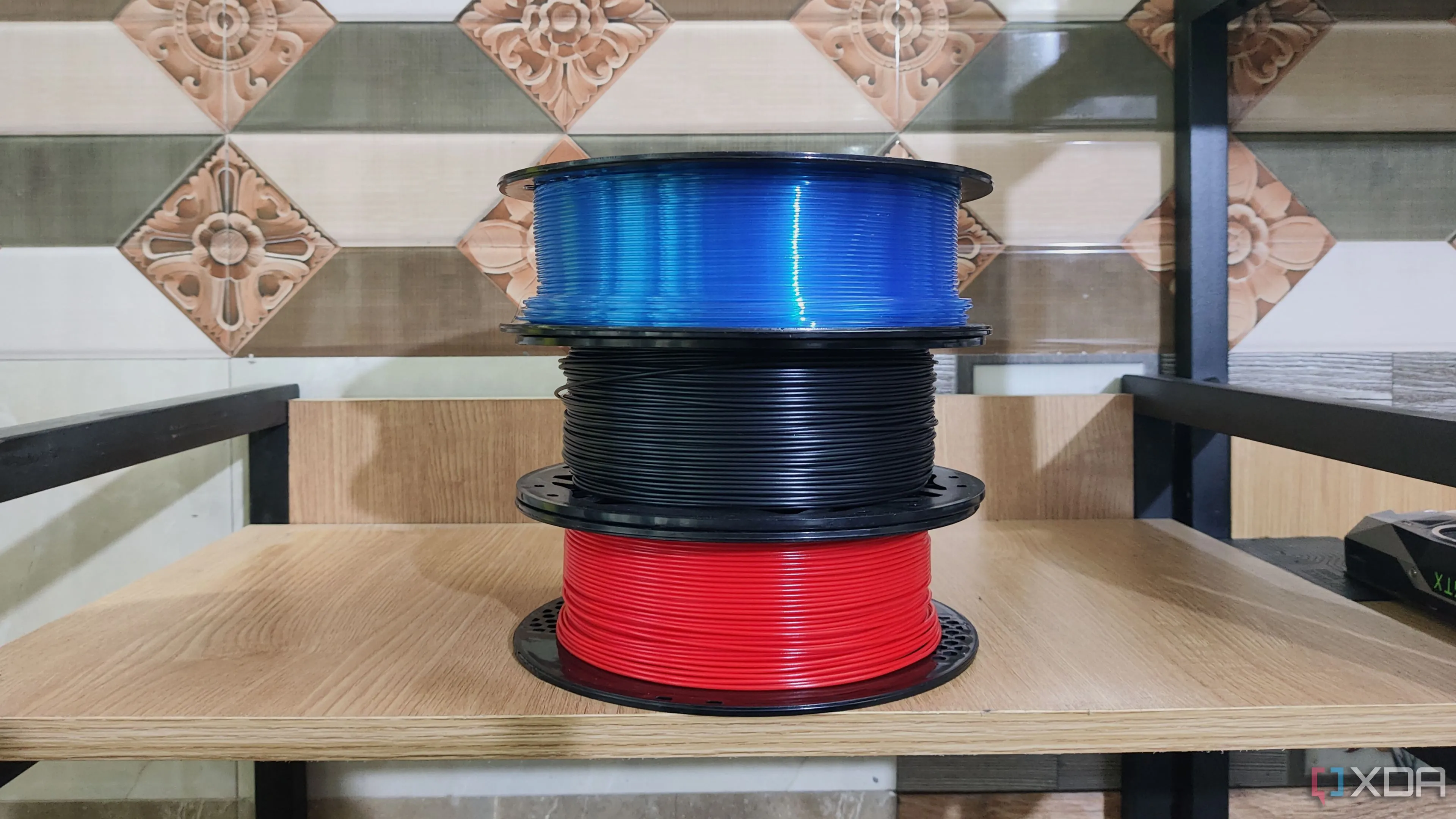 Ba cuộn sợi in 3D với kích thước và màu sắc khác nhau, minh họa nhu cầu về giá đỡ cuộn sợi lớn hơn.