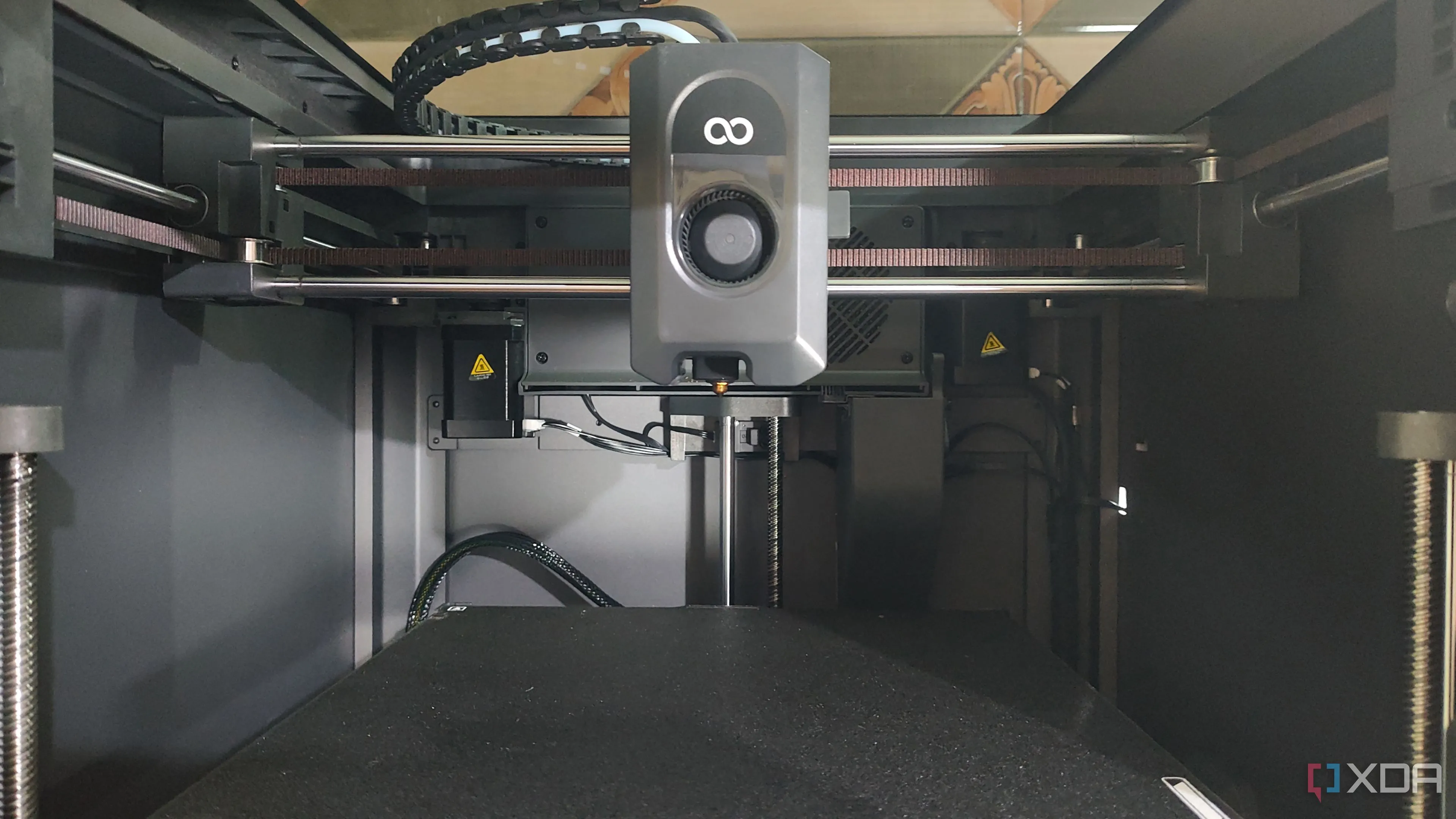 Bên trong máy in 3D Elegoo Centauri Carbon đang hoạt động, thể hiện khả năng nâng cấp và tùy biến thông qua việc tự in phụ kiện.