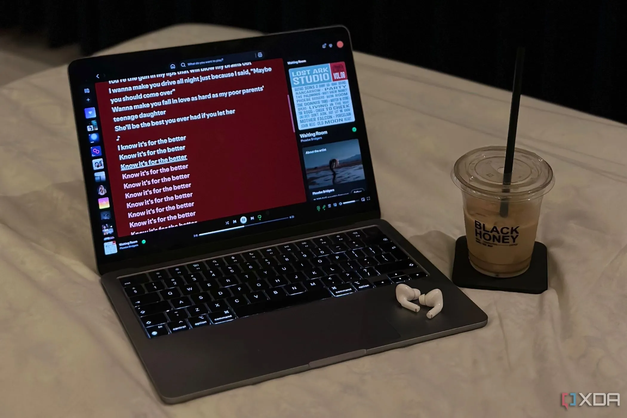 Cảnh quan làm việc thư giãn với MacBook, AirPods và ly cà phê, tượng trưng cho trải nghiệm sử dụng macOS.