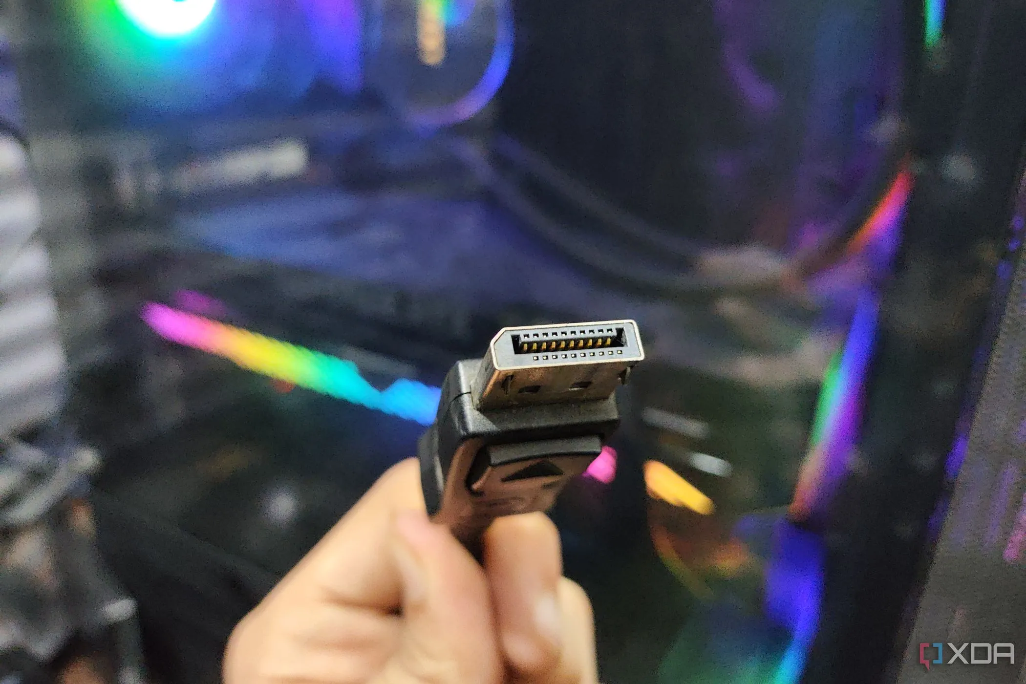 Cáp DisplayPort được giữ phía trước một chiếc PC, minh họa kết nối đồ họa