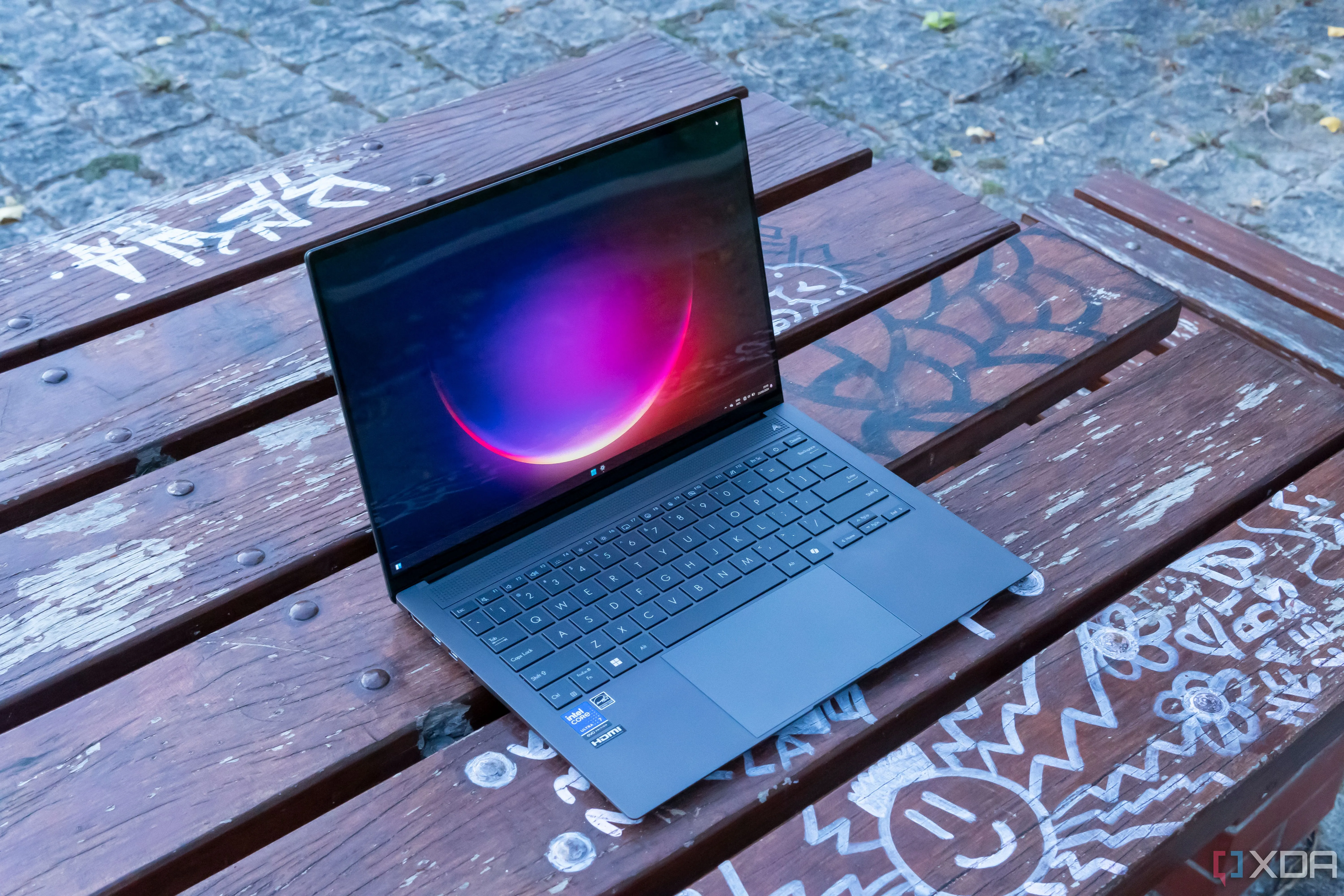 Góc nhìn chéo laptop Asus Zenbook S 14 hiển thị màn hình Windows 11, minh họa máy tính sử dụng ứng dụng cài đặt