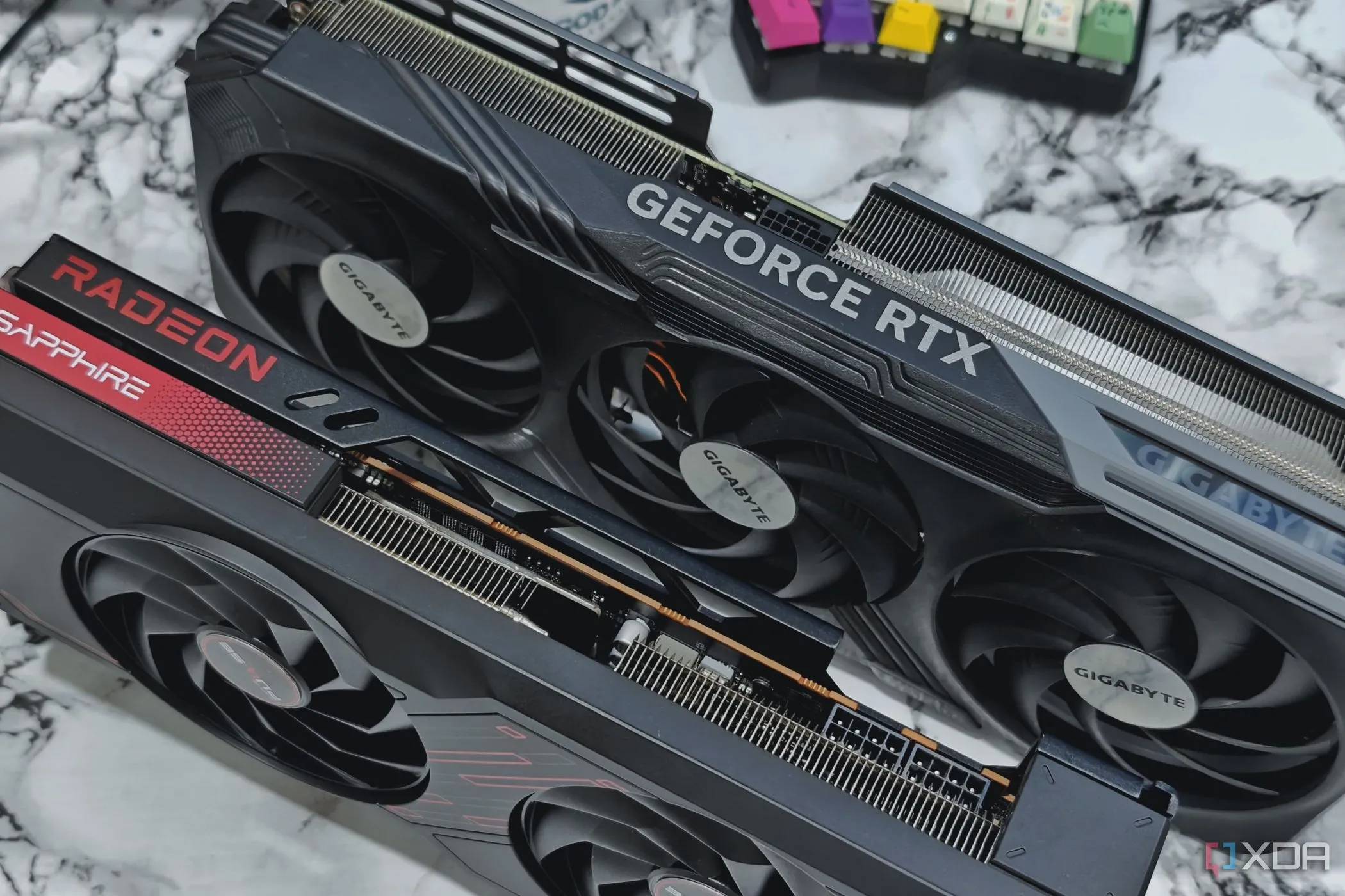 Hai card đồ họa NVIDIA GeForce RTX 4070 Ti và AMD Radeon RX 7700 XT trên bàn, tượng trưng cho sự lựa chọn GPU gaming.