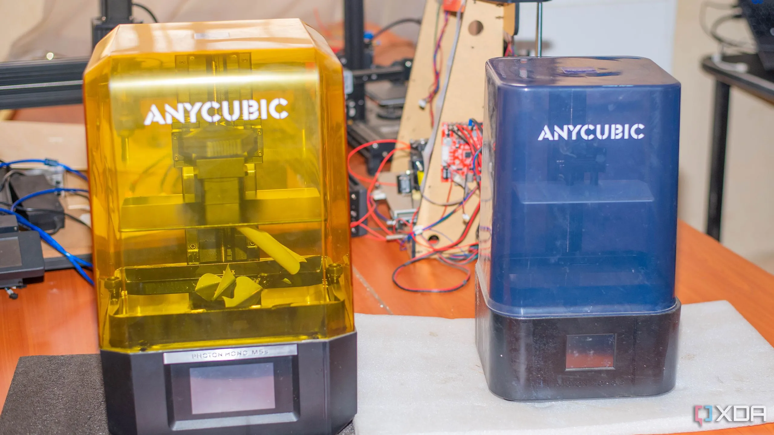 Hai máy in 3D resin Anycubic trên bàn, minh họa quá trình in chi tiết và đòi hỏi vệ sinh