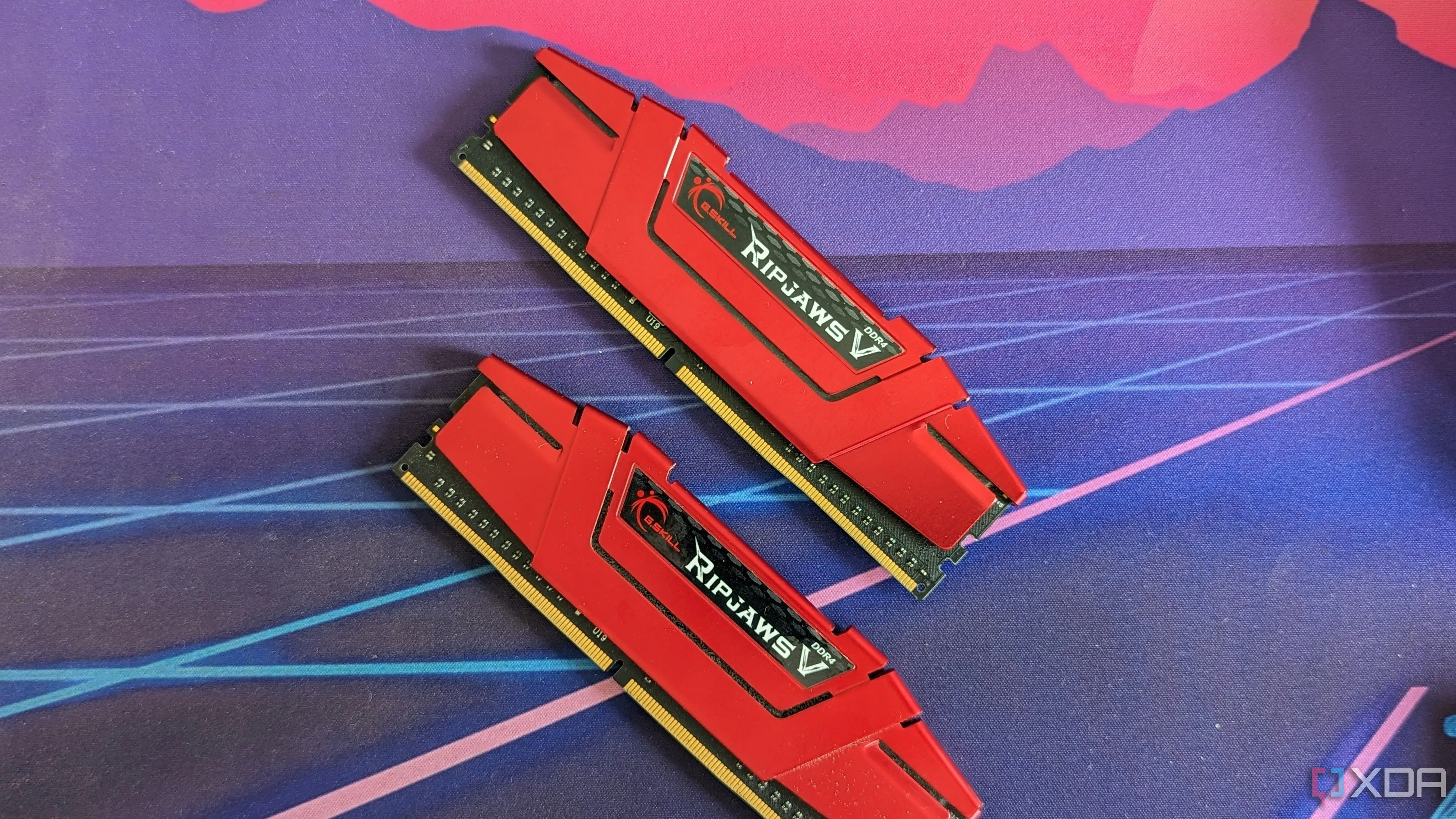Hai thanh RAM G.Skill Ripjaws DDR4 màu đỏ được đặt trên tấm lót bàn, biểu tượng cho các thế hệ RAM và khả năng ép xung.