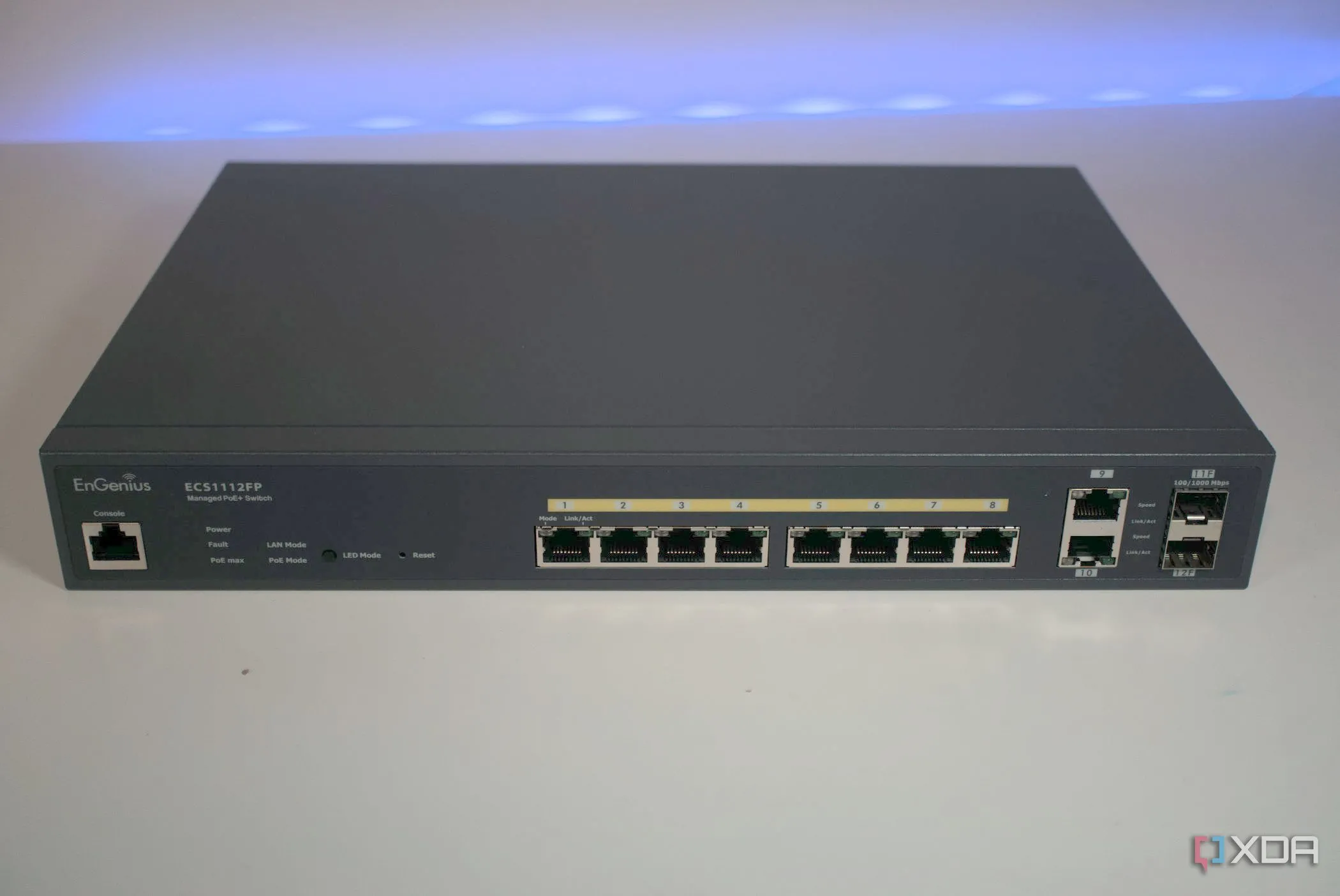 Hình ảnh mặt trước của một network switch EnGenius ECS112FP, minh họa giao diện giám sát và khắc phục sự cố mạng