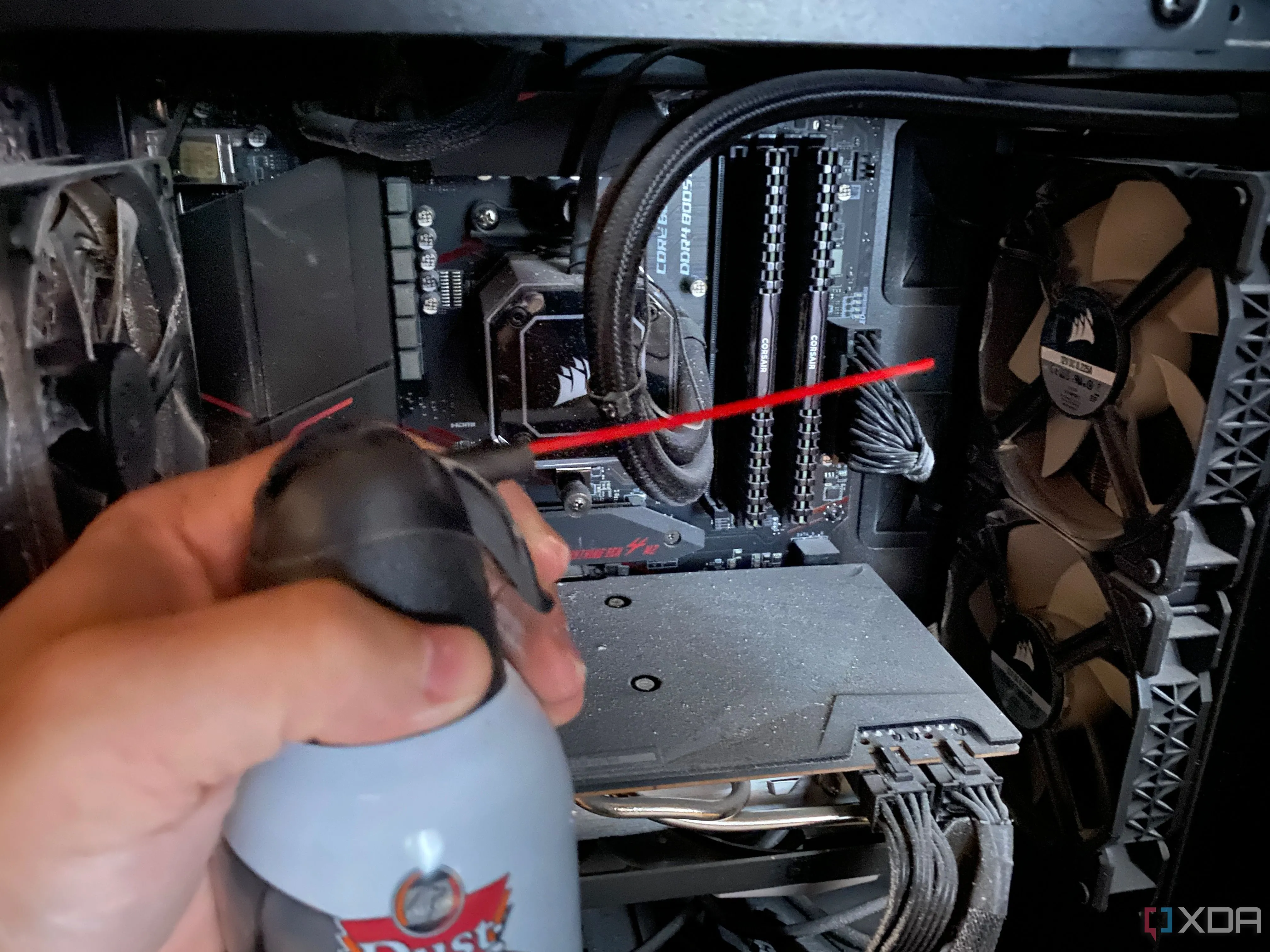 Kỹ thuật viên đang dùng khí nén vệ sinh case máy tính gaming bị bám bụi, giúp cải thiện luồng khí và tản nhiệt cho PC cũ.