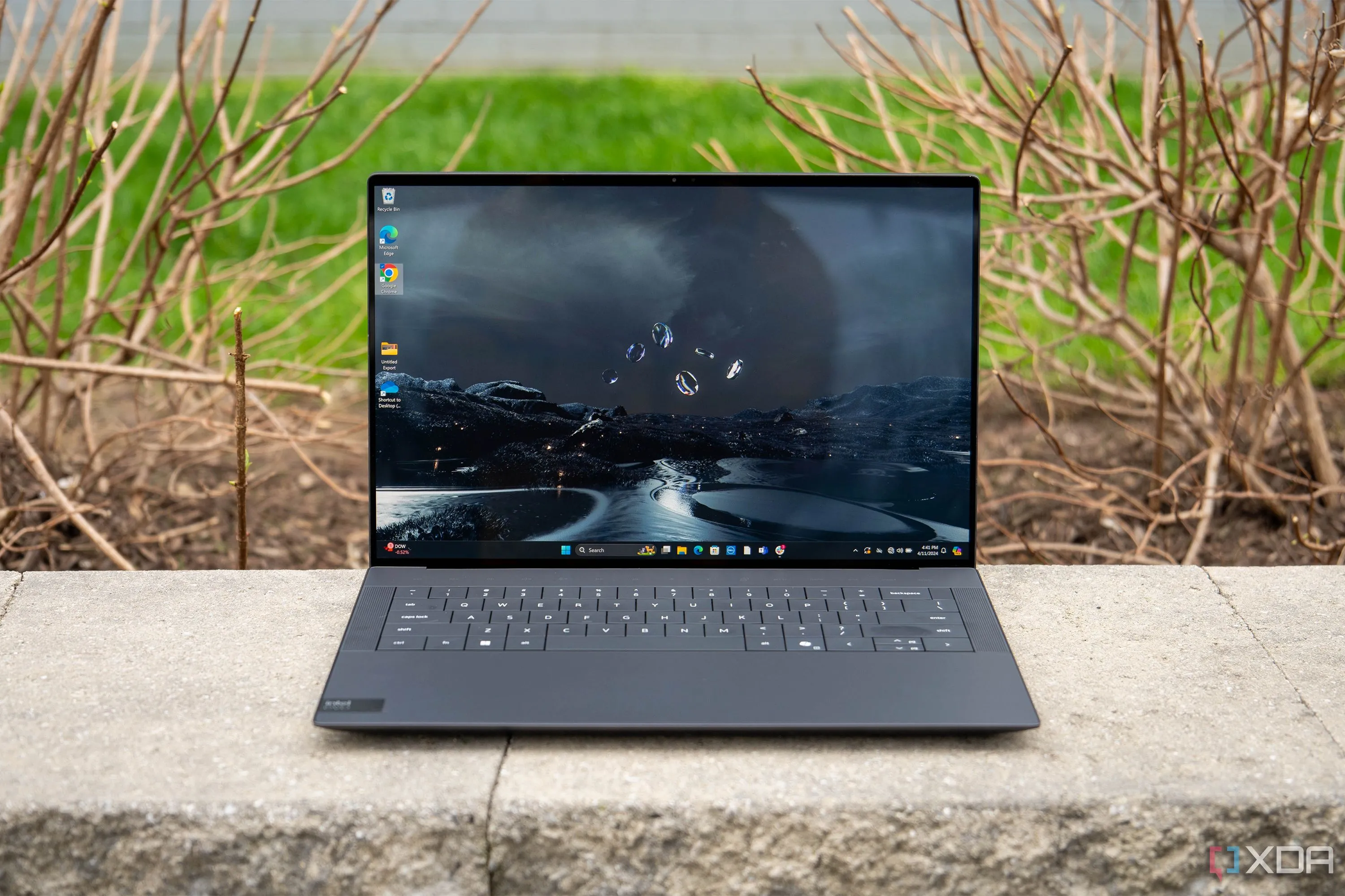 Laptop Dell XPS 14 màu bạc trên bàn làm việc, màn hình hiển thị nội dung
