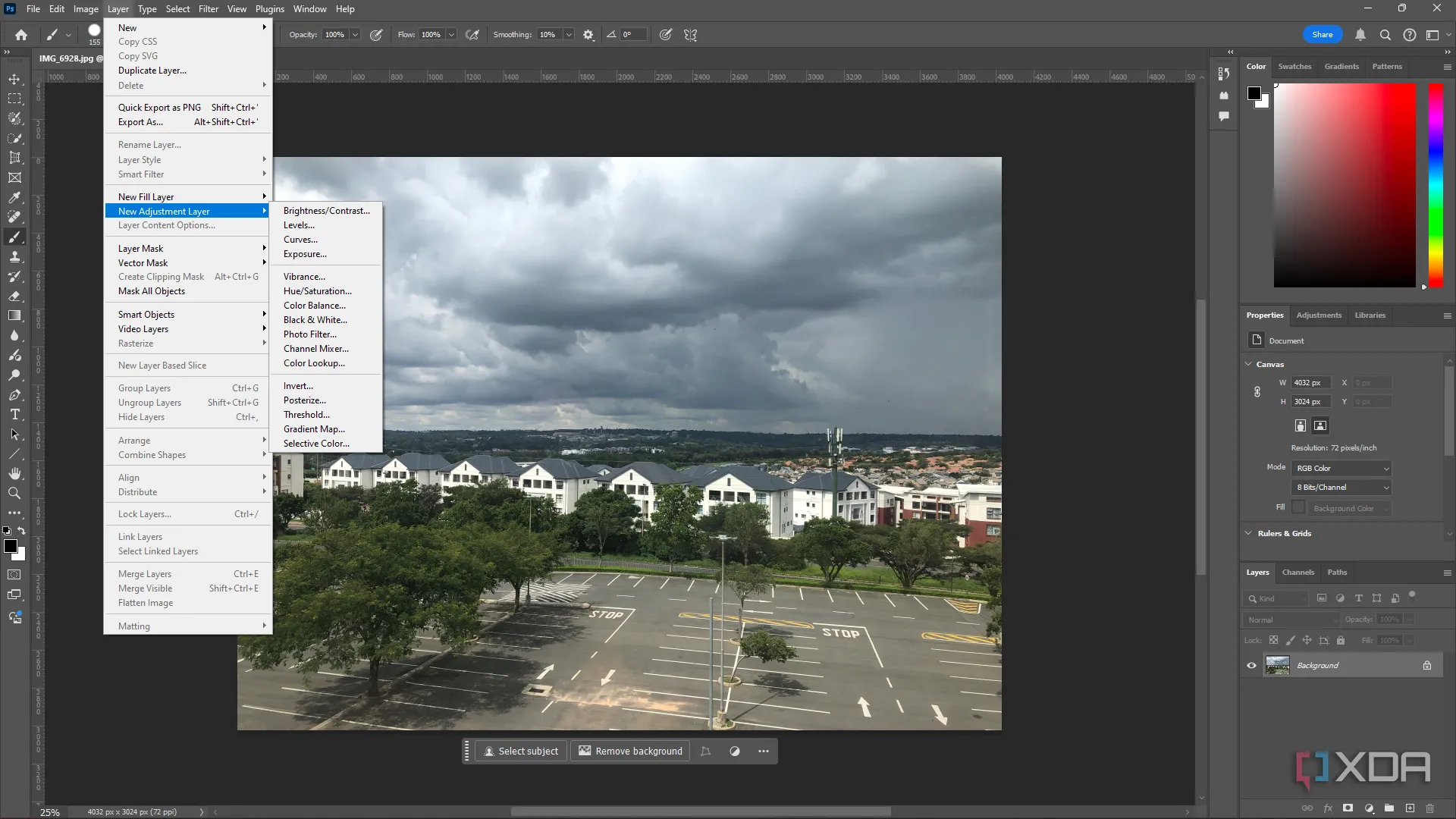 Màn hình Adobe Photoshop với ảnh phong cảnh thành phố và menu Layer đang mở, minh họa sự phức tạp của phần mềm.