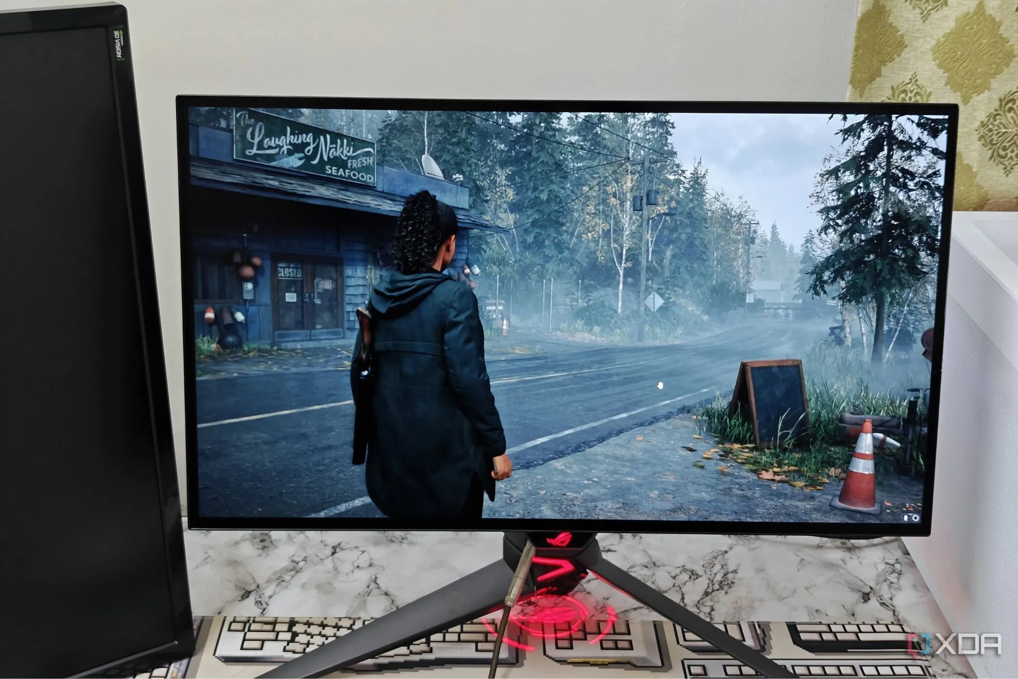 Màn hình gaming Asus ROG PG27AQDM hiển thị đồ họa chân thực của Alan Wake 2, thể hiện sức mạnh đồ họa PC.