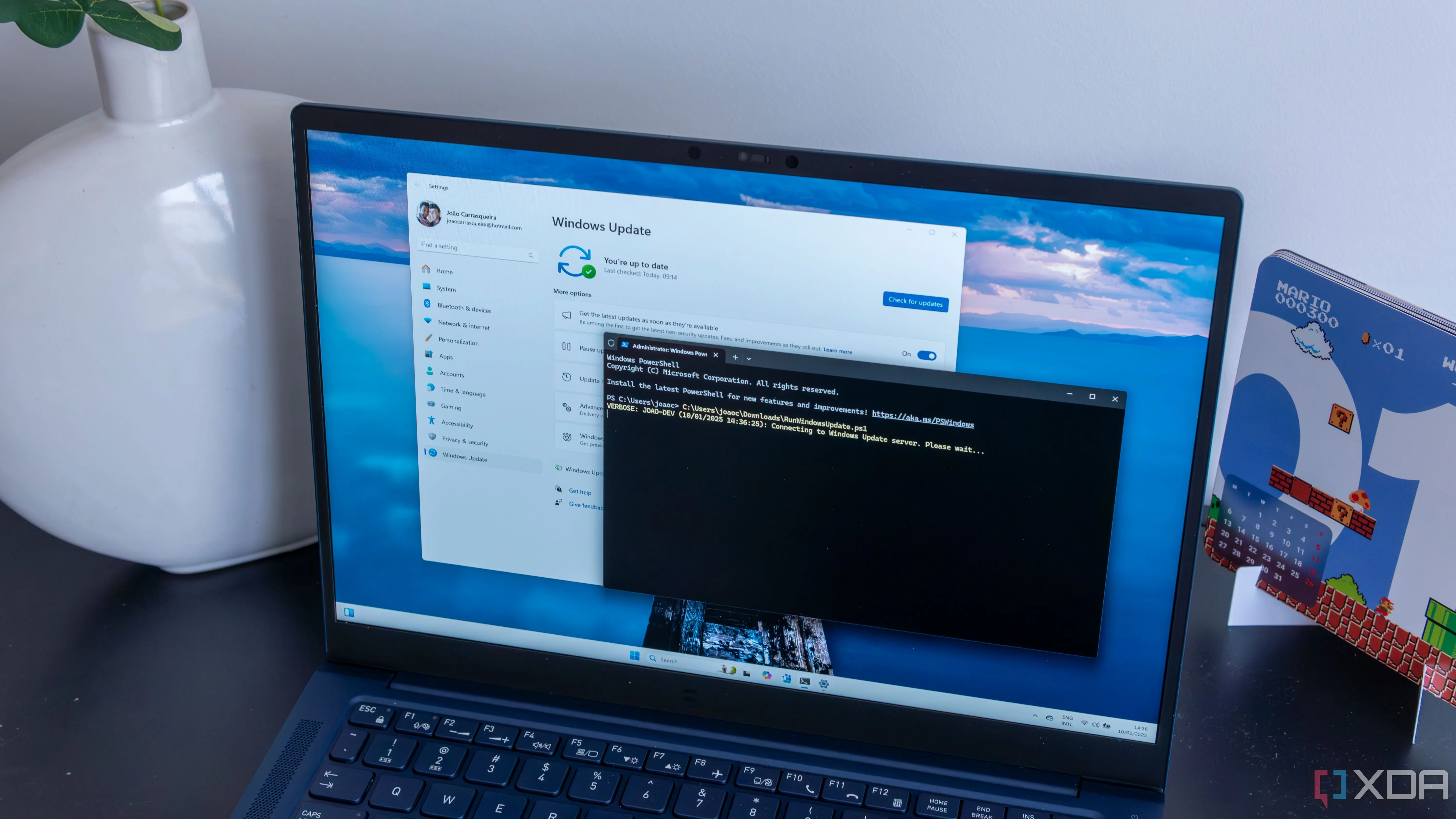 Máy tính xách tay Windows 11 hiển thị cửa sổ PowerShell đang chạy script tự động cập nhật và khởi động lại