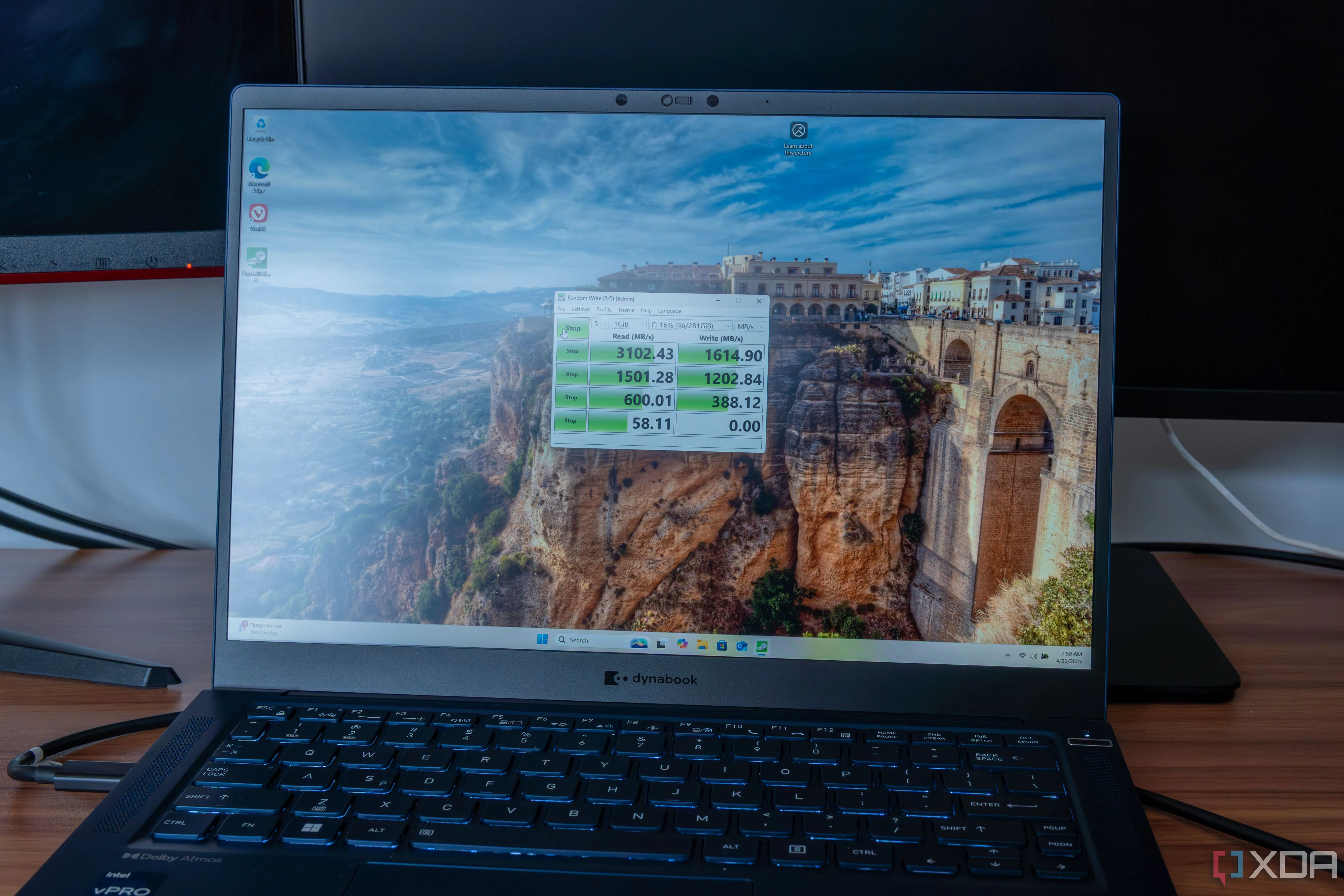 Một chiếc laptop Windows 11 đang chạy bài kiểm tra CrystalDiskMark