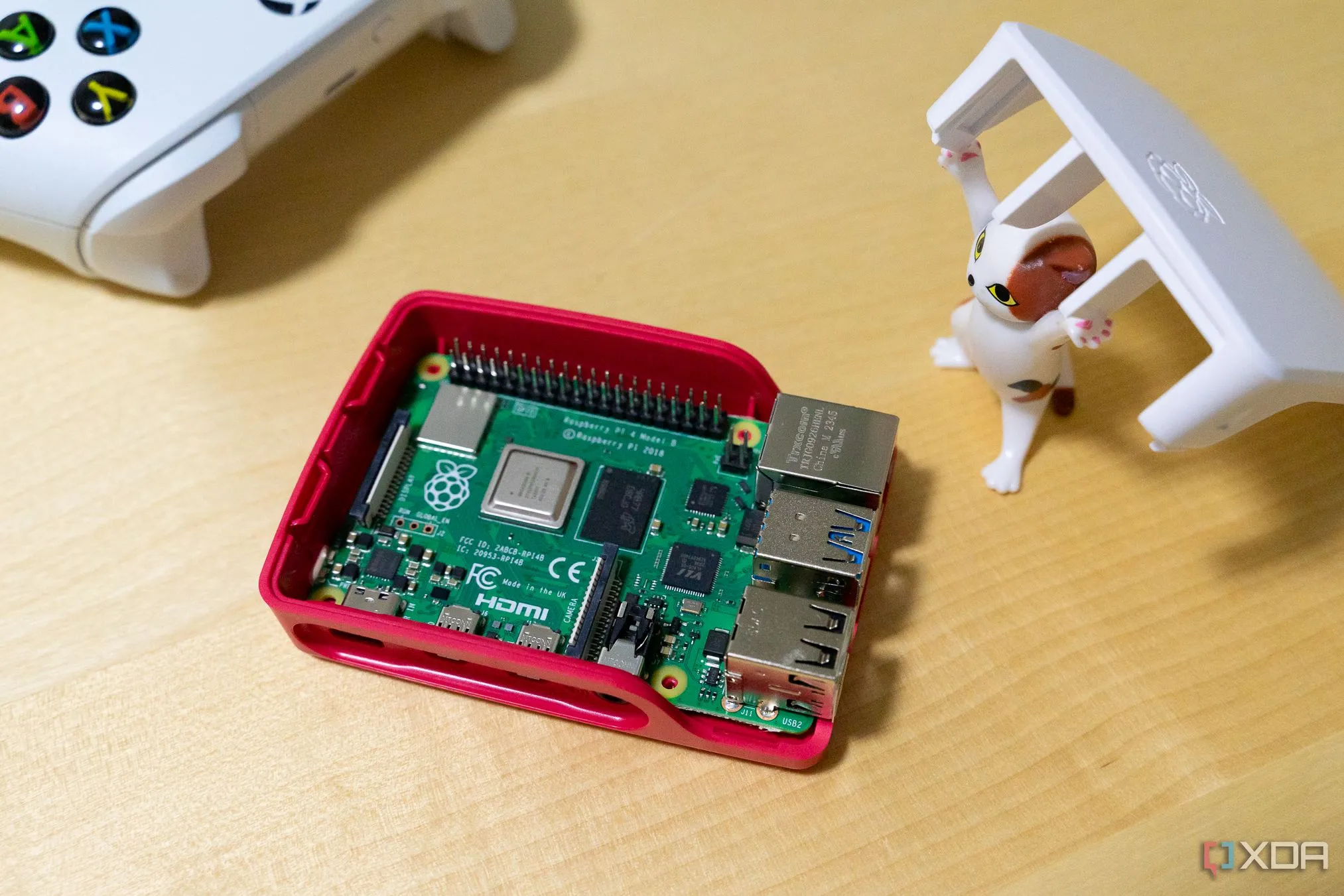 Một mô hình mèo đồ chơi đang nhấc nắp hộp để lộ bo mạch Raspberry Pi bên trong.