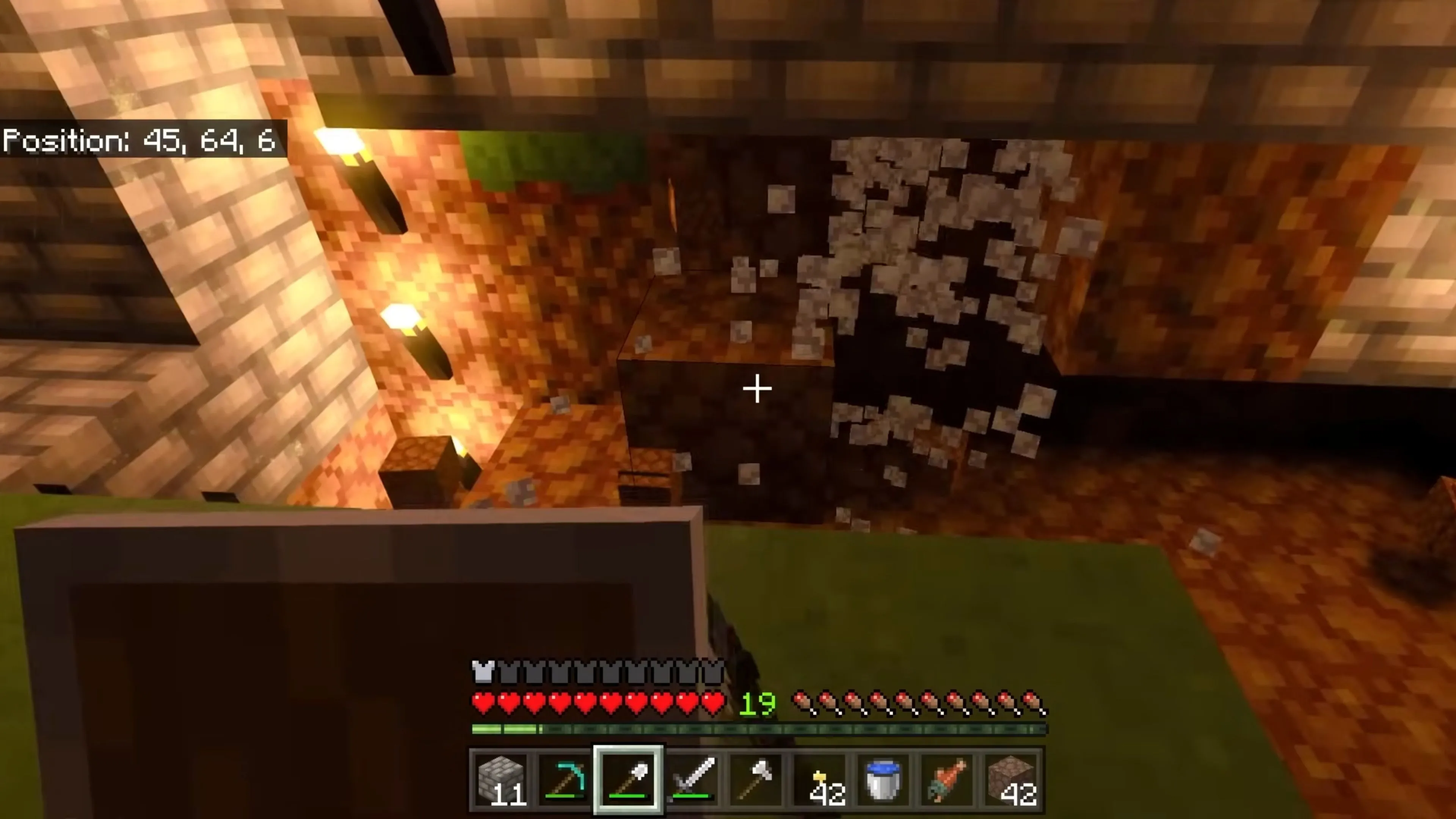 Một ngôi nhà nhỏ được xây dựng trong Minecraft vào ban đêm, với đèn đuốc thắp sáng, tạo cảm giác ấm cúng và an toàn.