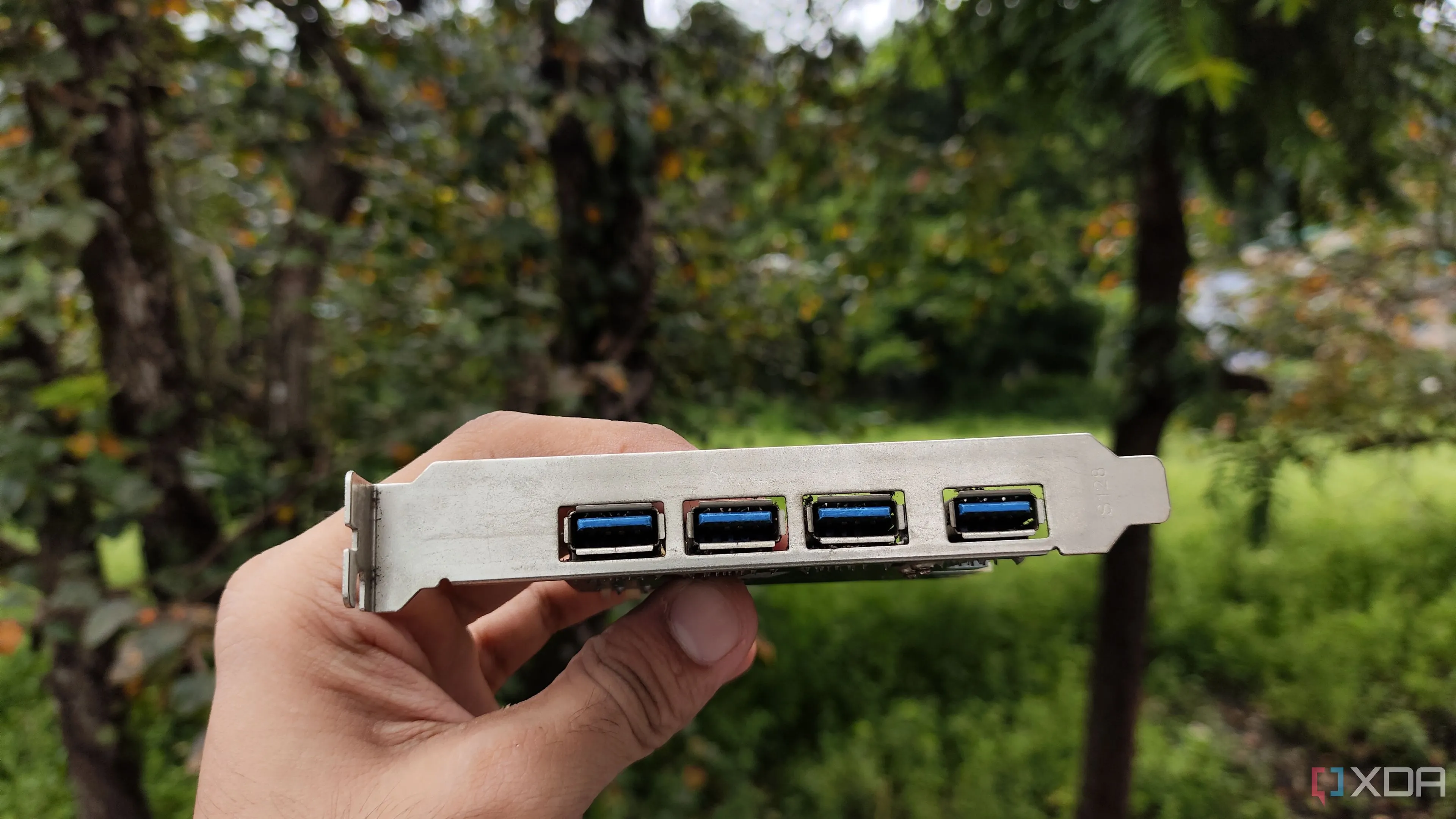 Một người cầm một card mở rộng USB PCIe