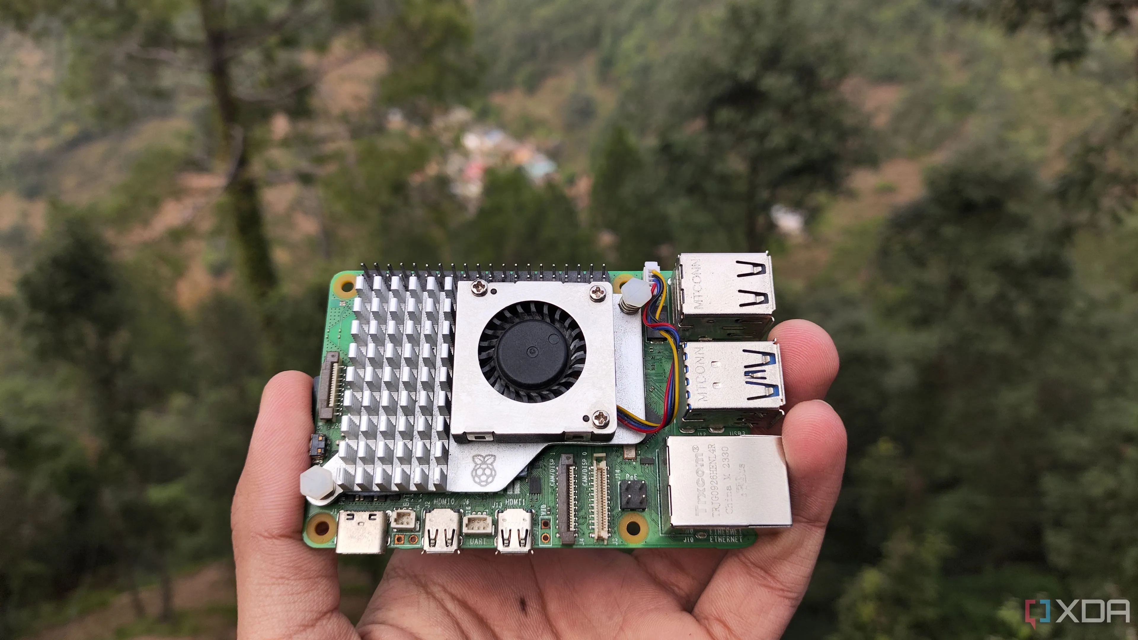 Một người đang cầm bo mạch Raspberry Pi 5, thiết bị phổ biến để cài đặt Pi-hole và các dự án home lab