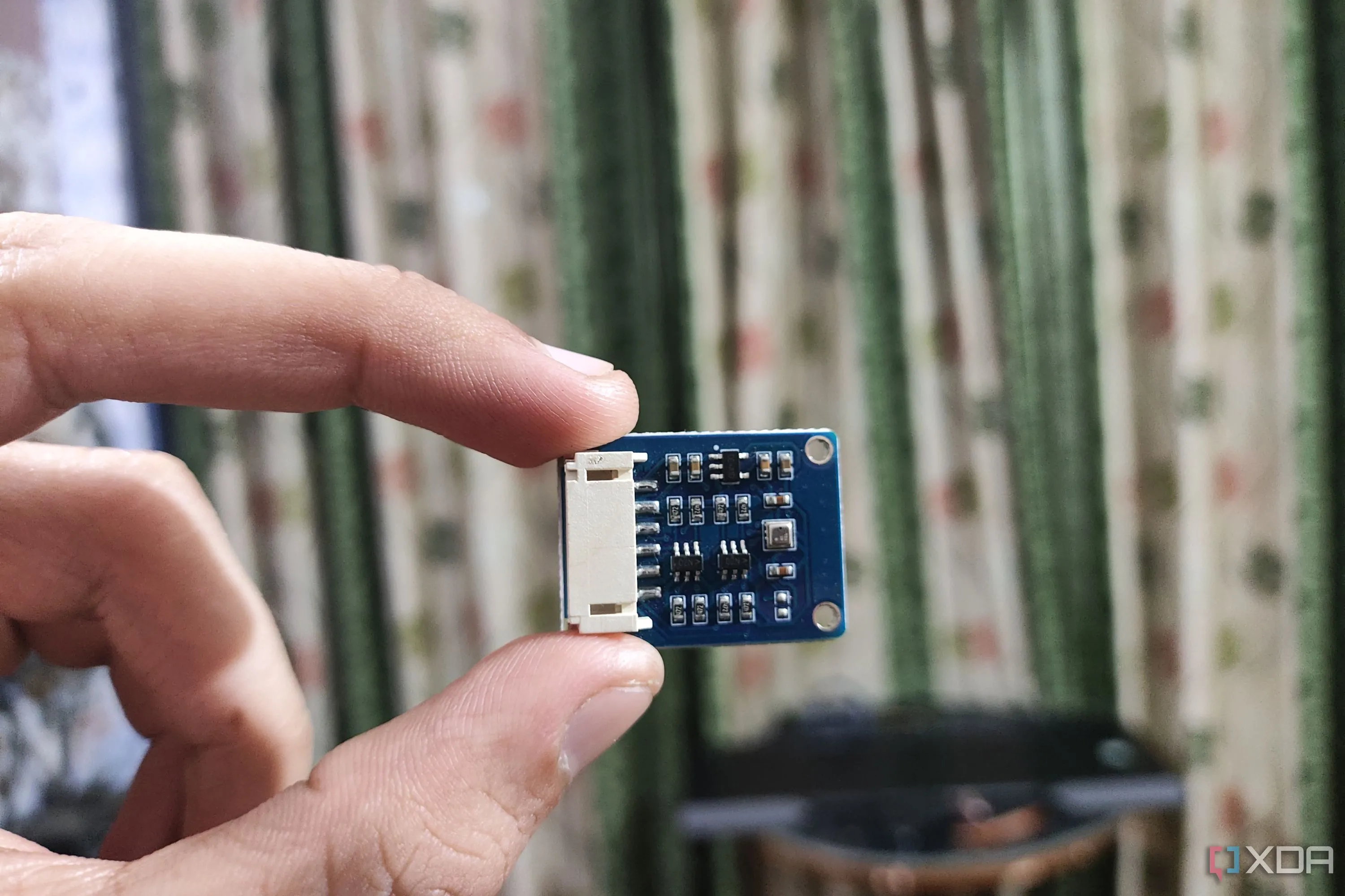 Một người đang cầm cảm biến BME280 để đo nhiệt độ môi trường