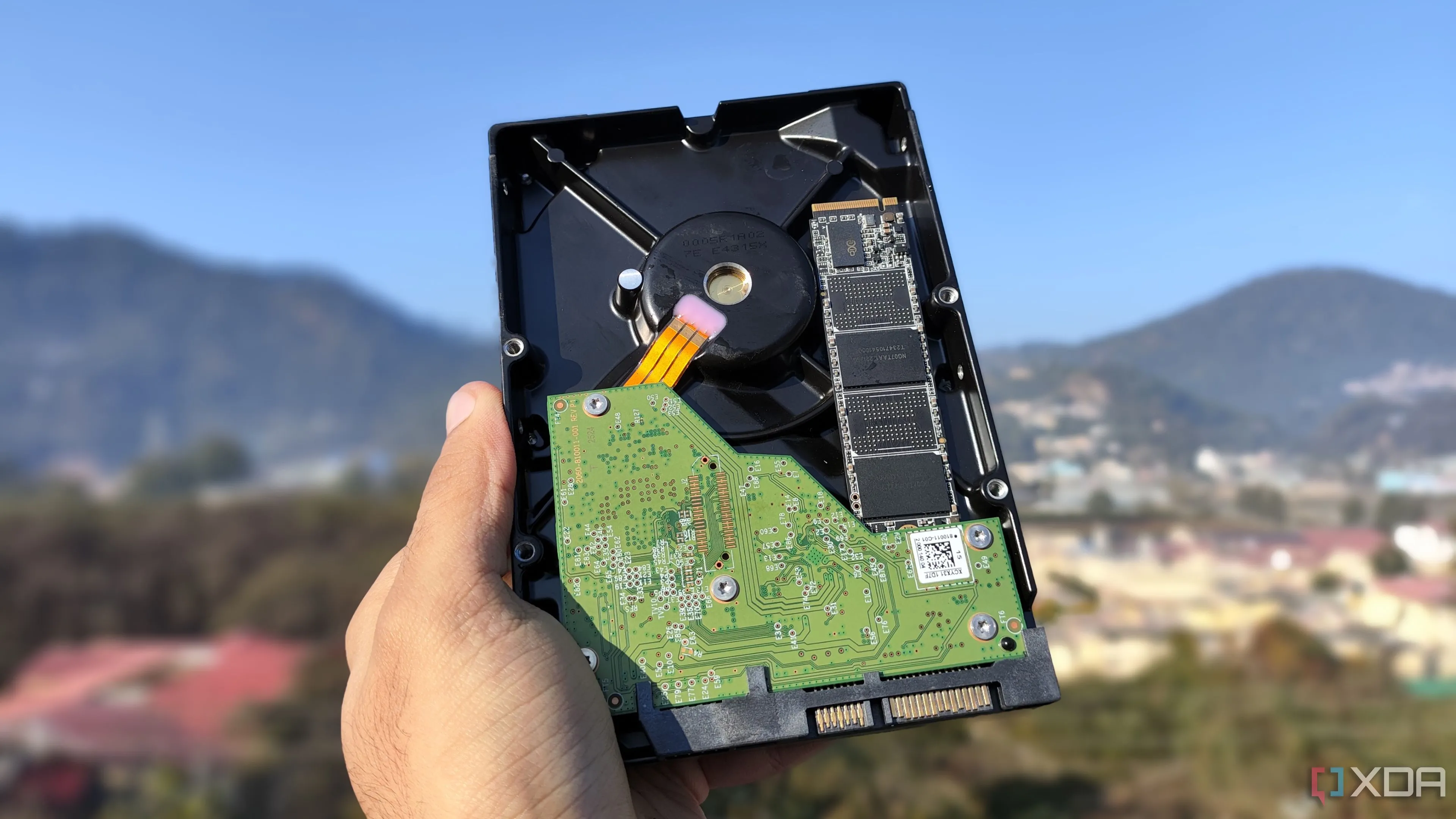 Một người đang cầm ổ cứng HDD và SSD, minh họa sự khác biệt trong lưu trữ và sao lưu dữ liệu
