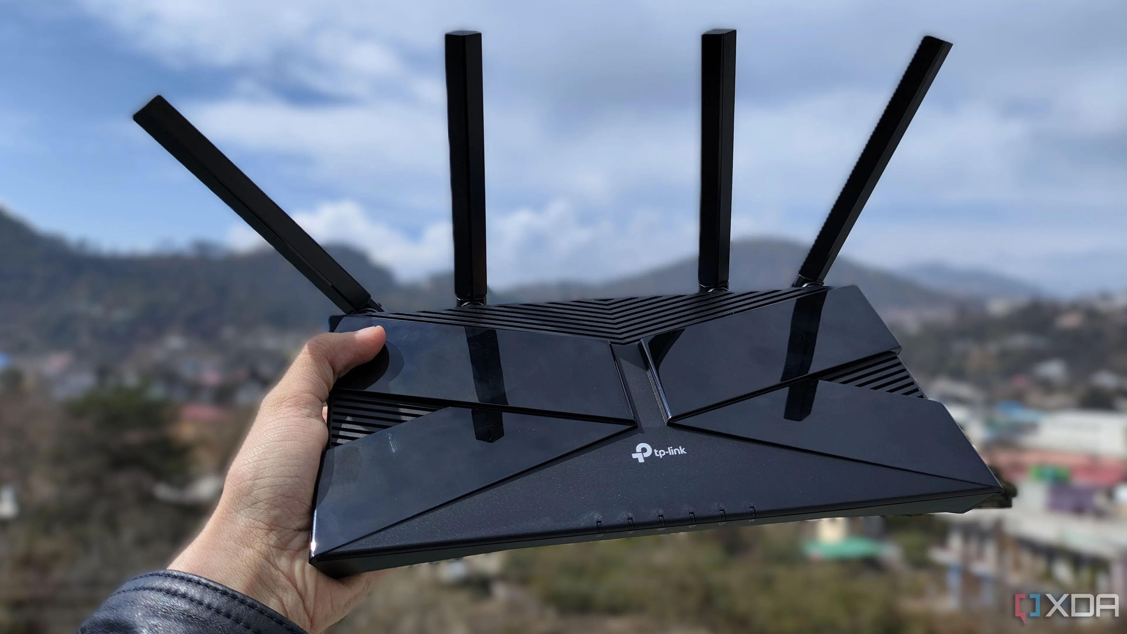 Một người đang cầm router TP-Link, biểu tượng cho router nhà mạng thông thường
