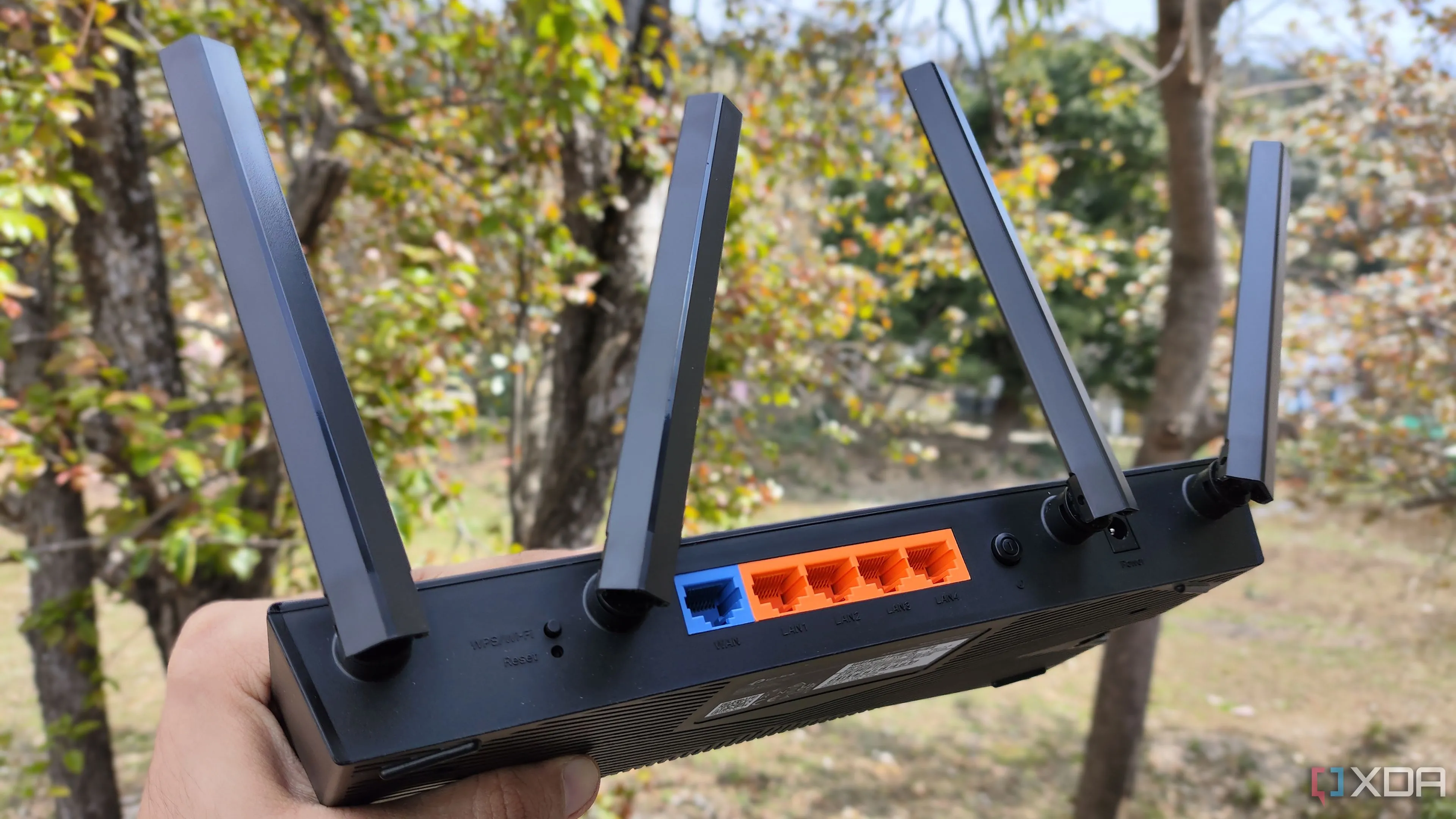 Một người đang cầm router TP-Link, tượng trưng cho việc quản lý và cấu hình các thiết lập bảo mật mạng