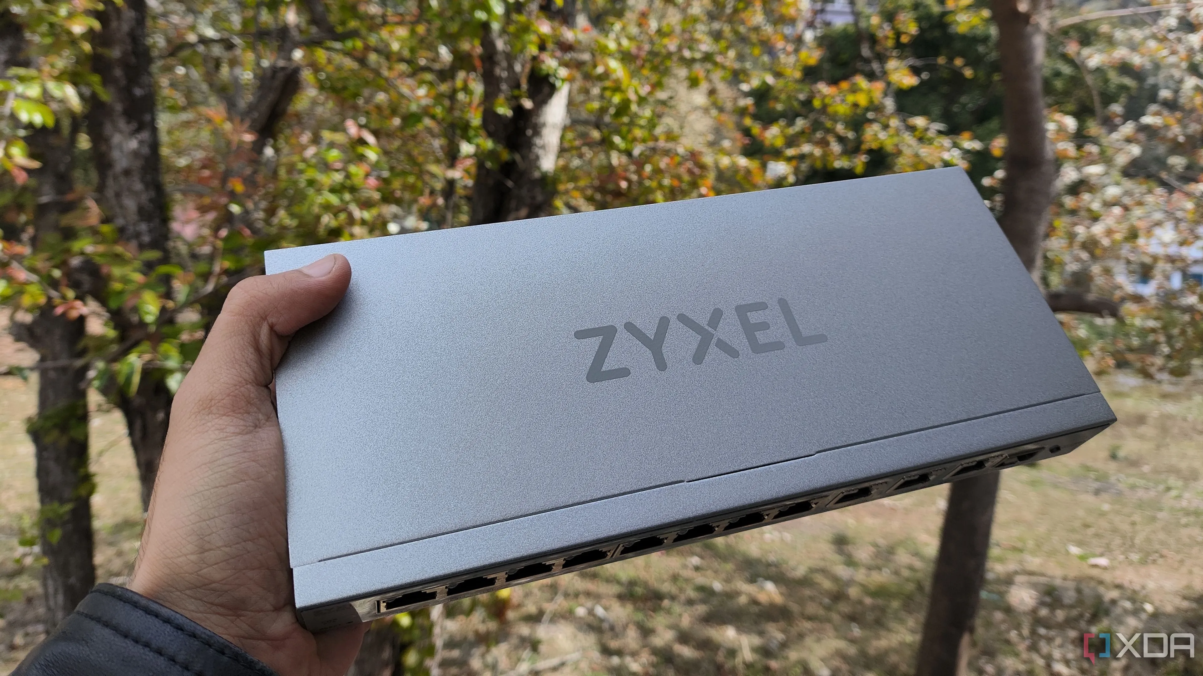Một người đang cầm switch mạng Zyxel 10GbE, biểu tượng cho thiết bị mạng hiệu suất cao nhưng cần cân nhắc trước khi đầu tư