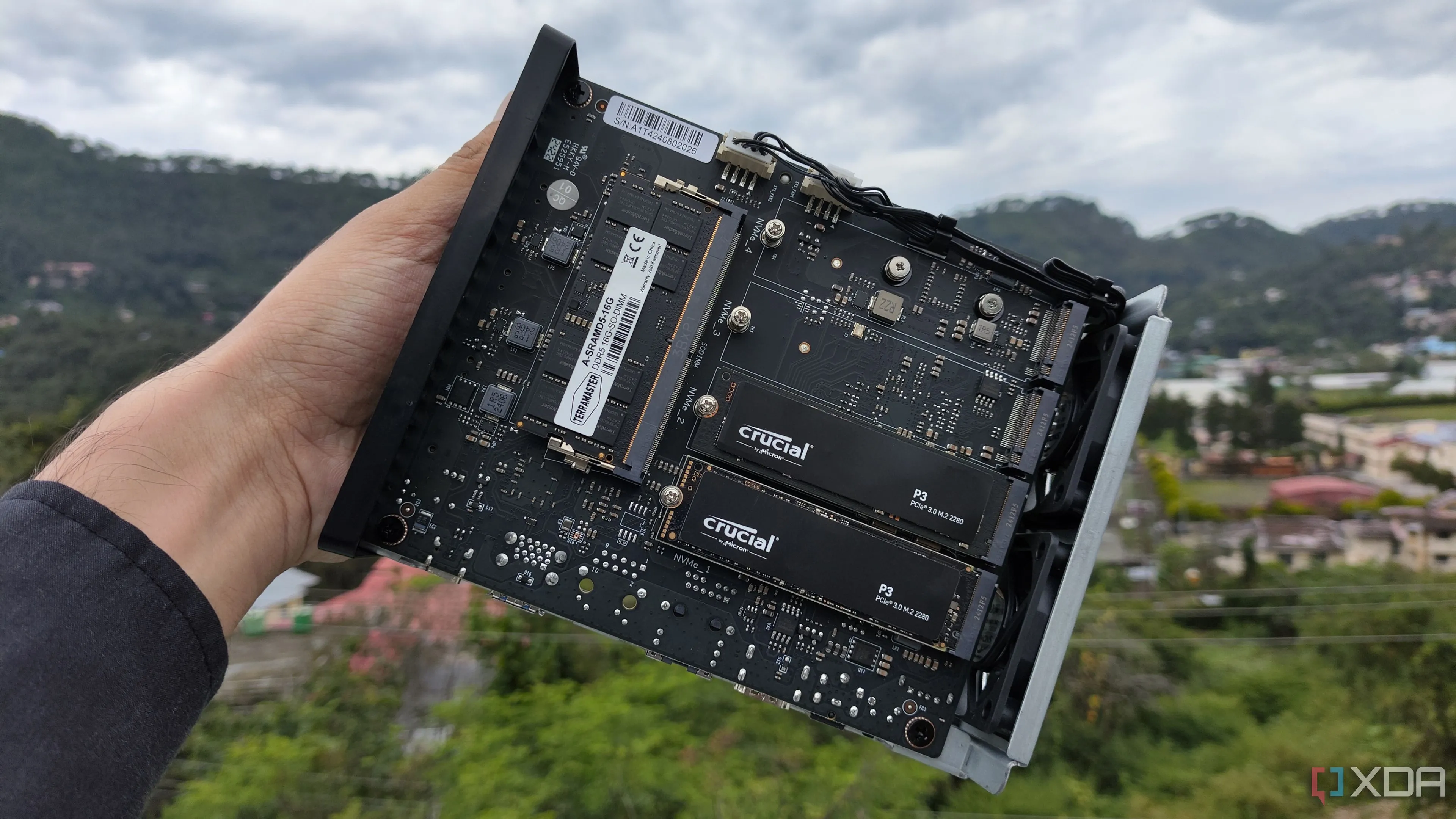 Một người đang cầm TerraMaster F8 SSD Plus với hai ổ SSD PCIe 3 gắn bên trong, minh họa giải pháp lưu trữ NAS chuyên nghiệp