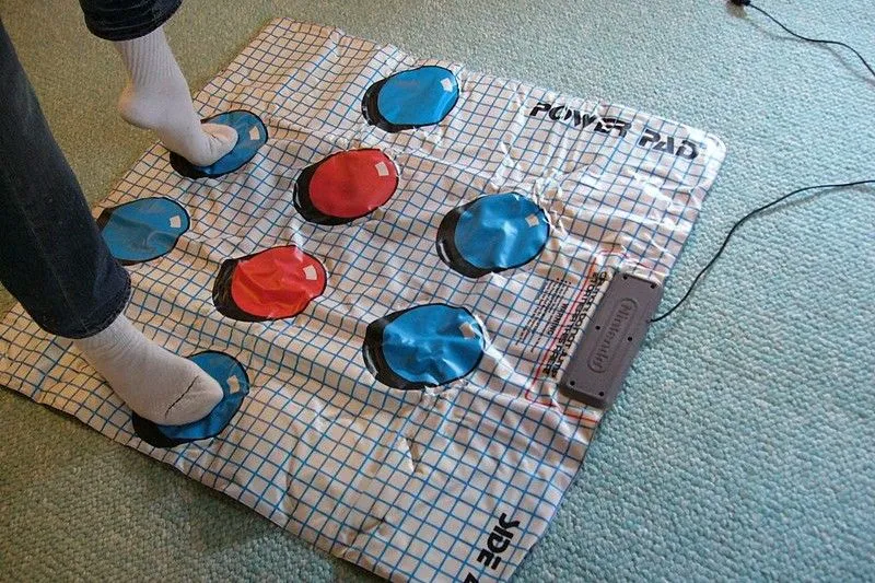 Một người đang đứng trên tấm thảm NES Power Pad để chơi game thể dục