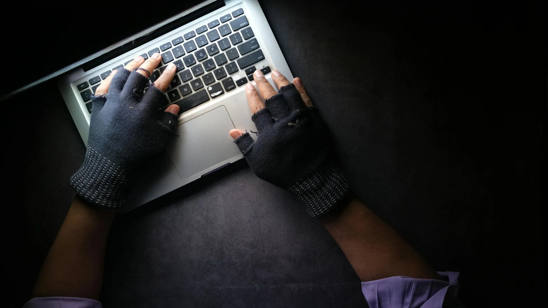 Một người đang gõ bàn phím laptop, liên quan đến virus ghi đè (overwrite virus) có thể xóa vĩnh viễn dữ liệu gốc và làm suy giảm hiệu suất hệ thống.