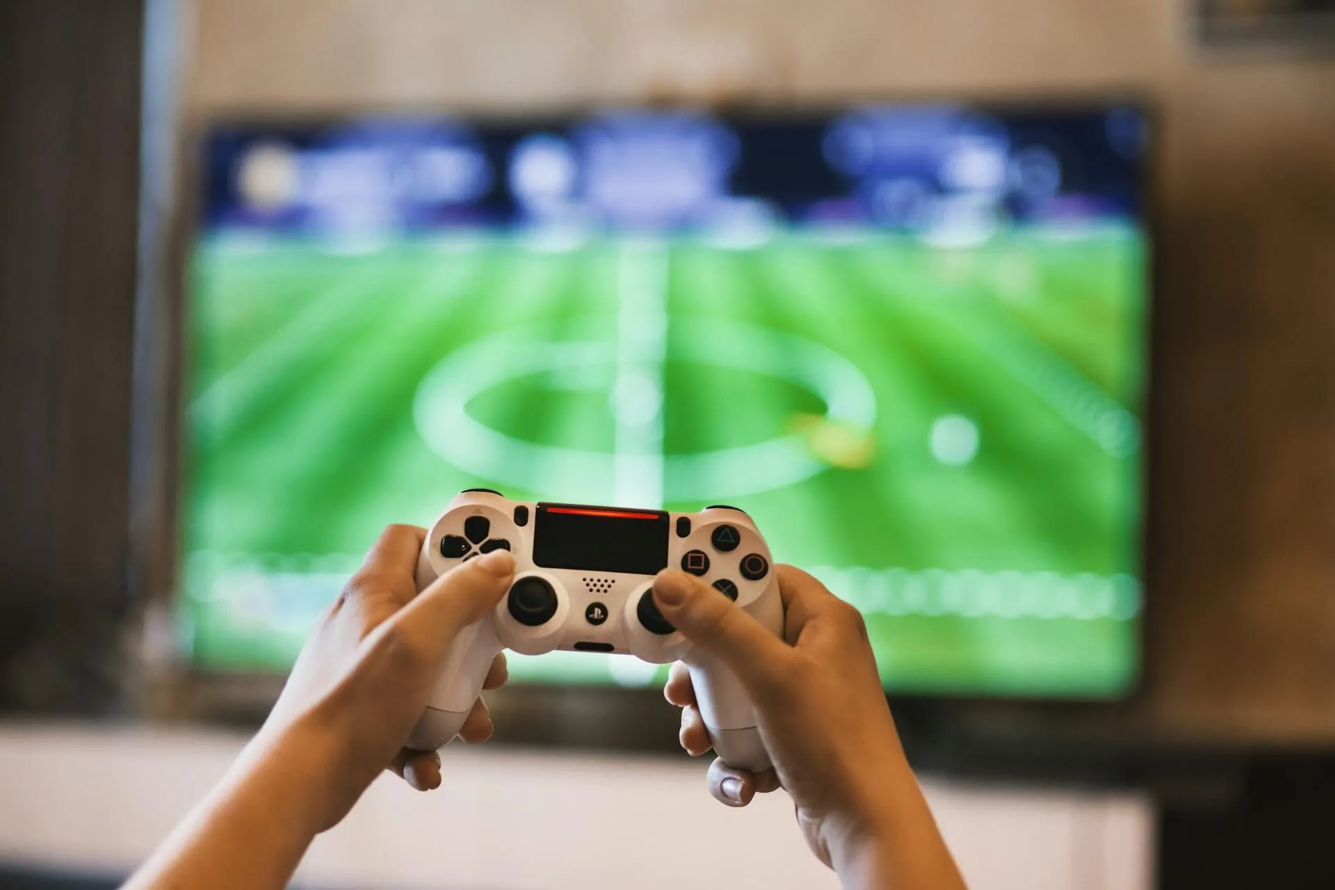 Người chơi game trên PlayStation 4 với tay cầm, tượng trưng cho trải nghiệm chơi game mượt mà với Wi-Fi 7