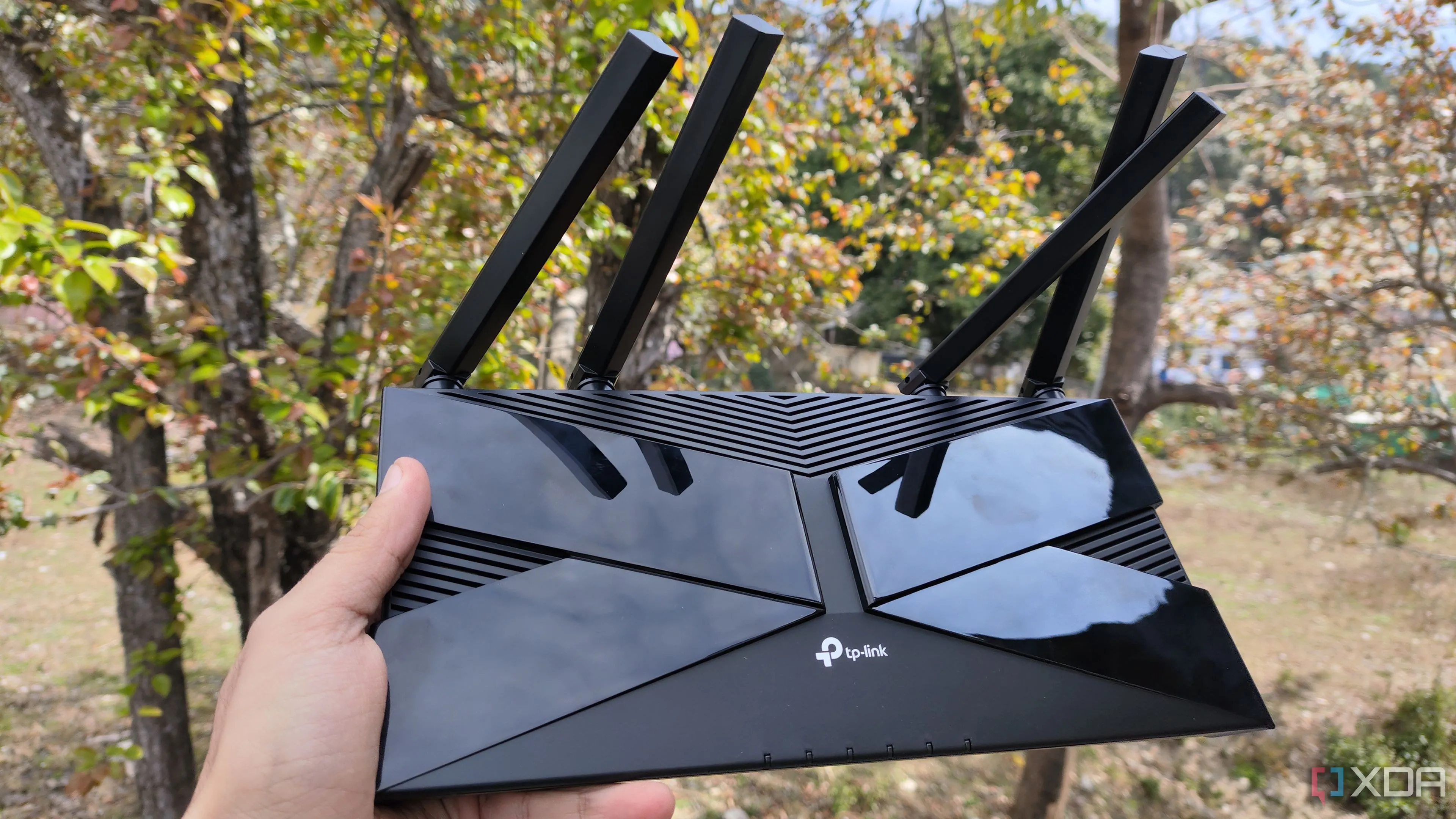 Người dùng cầm bộ định tuyến TP-Link, minh họa khả năng giám sát thiết bị mạng qua giao thức SNMP trong Home Assistant.