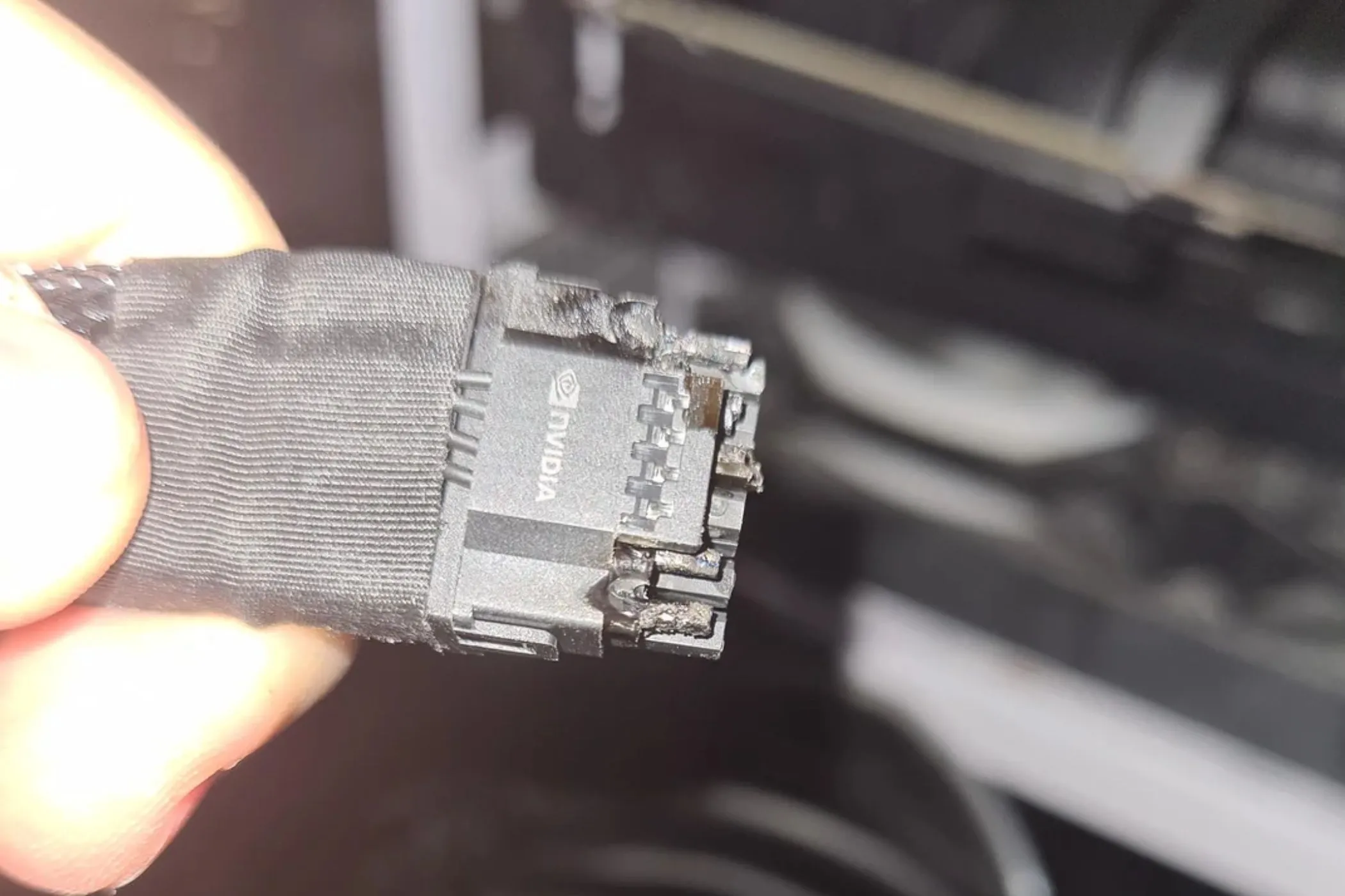 Người dùng cầm đầu nối 12VHPWR bị cháy trên card RTX 4090, minh chứng sự cố lỗi cáp nguồn.