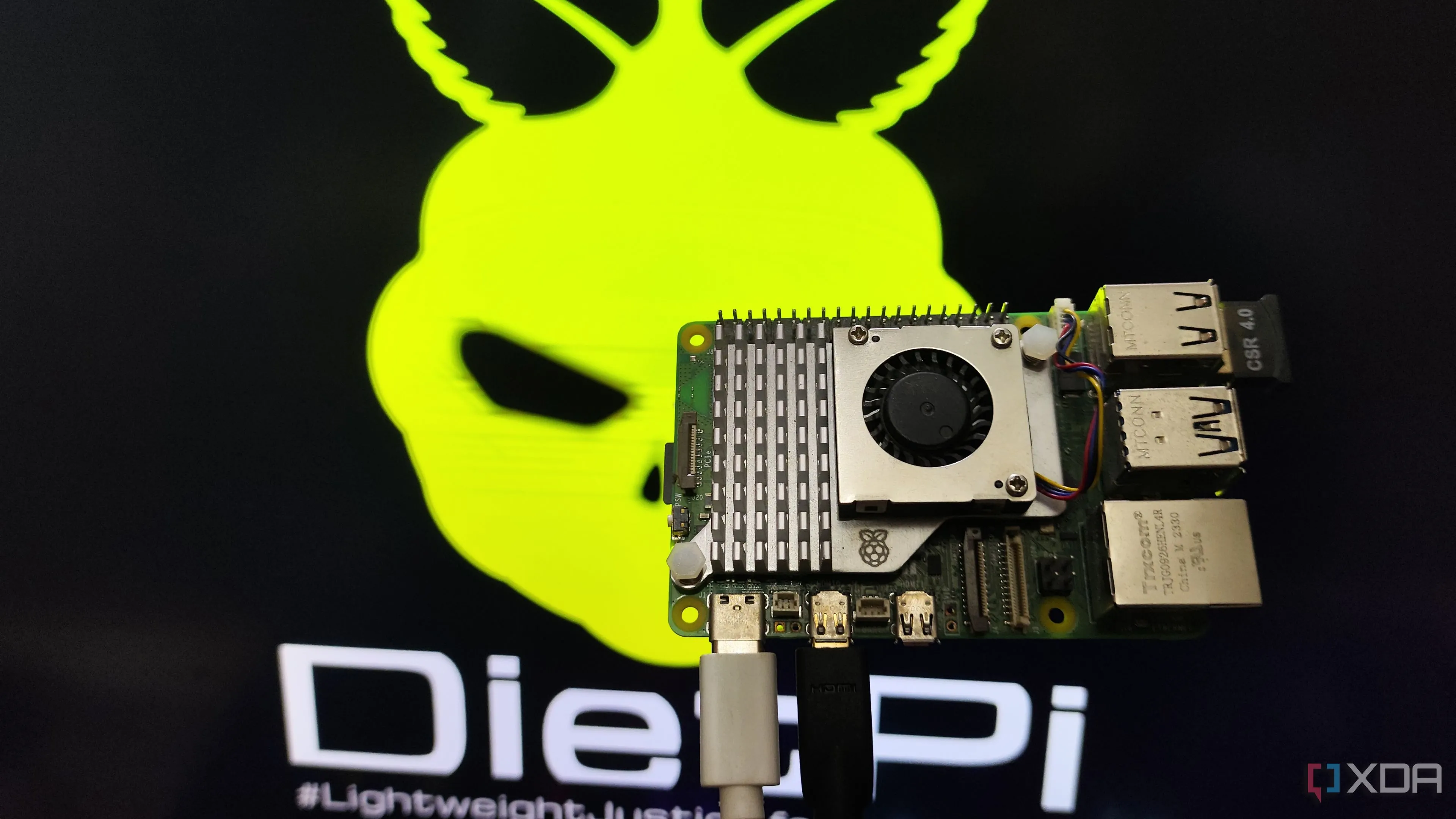 Người dùng cầm Raspberry Pi 5 với màn hình hiển thị giao diện DietPi LXDE, minh họa khả năng chạy trên SBCs