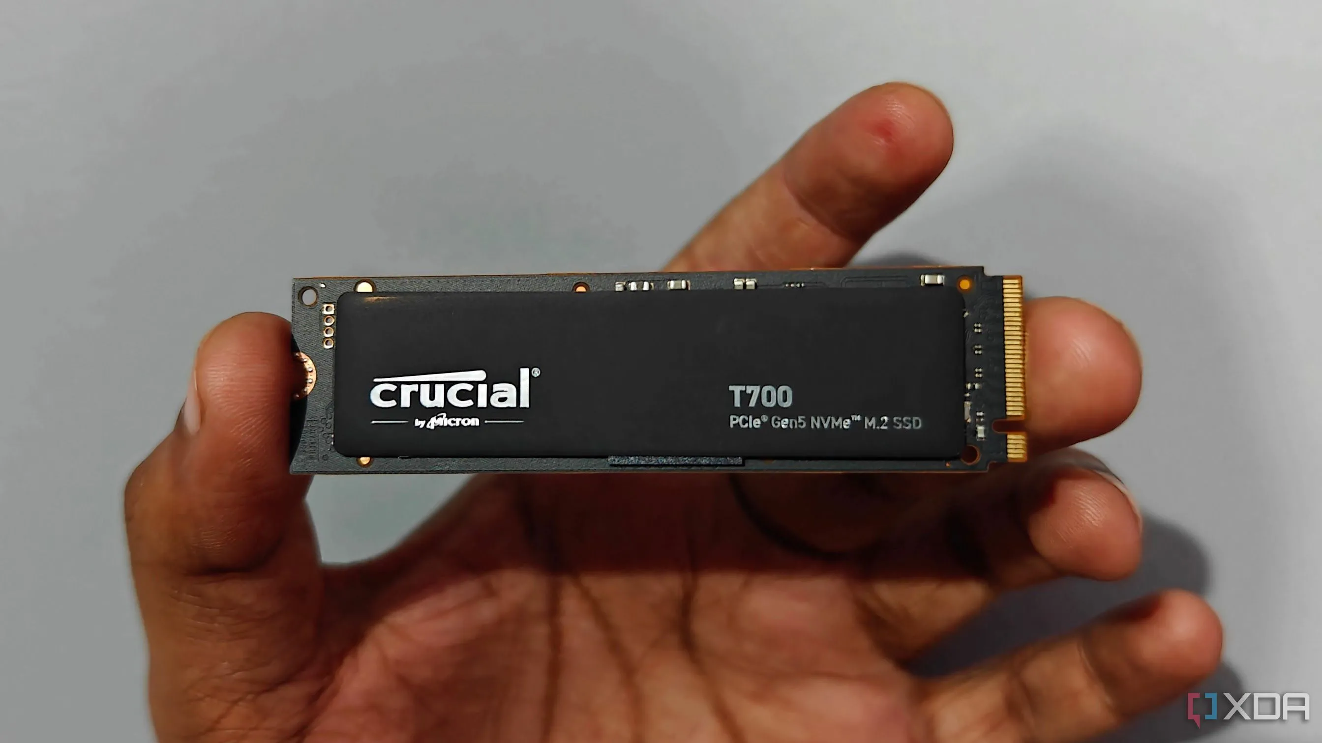 Người dùng cầm trên tay ổ cứng SSD Crucial T700, so sánh chi phí giữa SSD Gen4 và Gen5