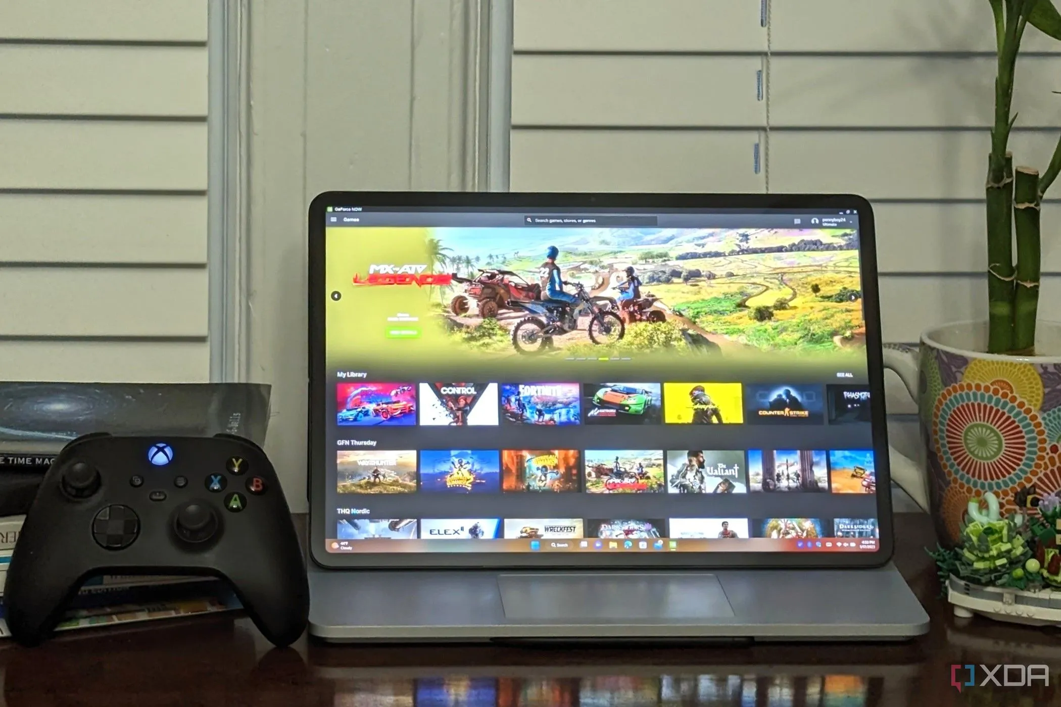 Người dùng trải nghiệm Nvidia GeForce Now Ultimate trên laptop kèm tay cầm Xbox