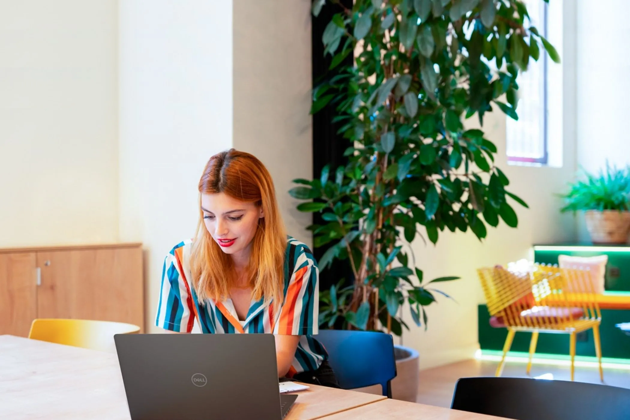Người phụ nữ đang làm việc trên laptop Dell, tượng trưng cho workstation di động được tối ưu bằng SSD Gen 5