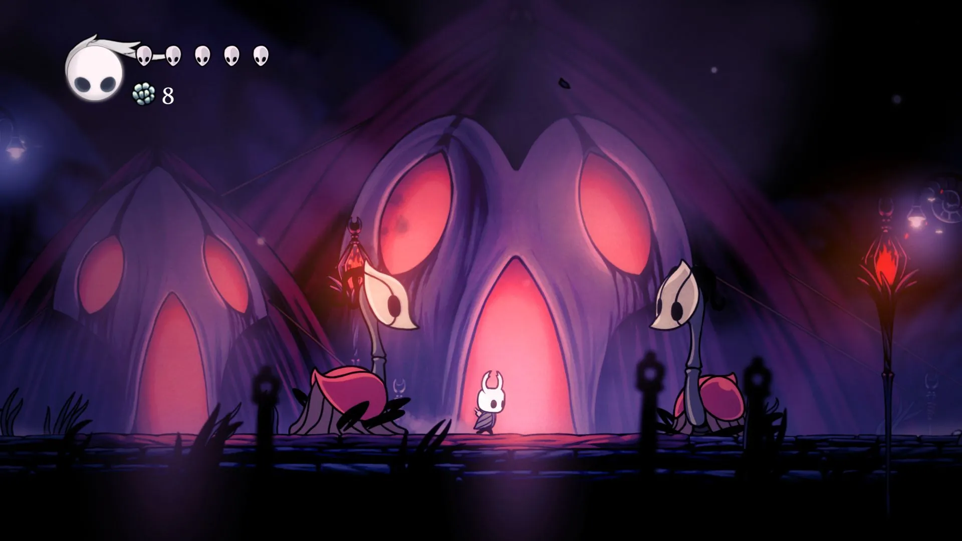 Nhân vật chính của game Hollow Knight đứng giữa hai sinh vật, minh họa một trong những tựa game kinh điển có tầm ảnh hưởng lớn