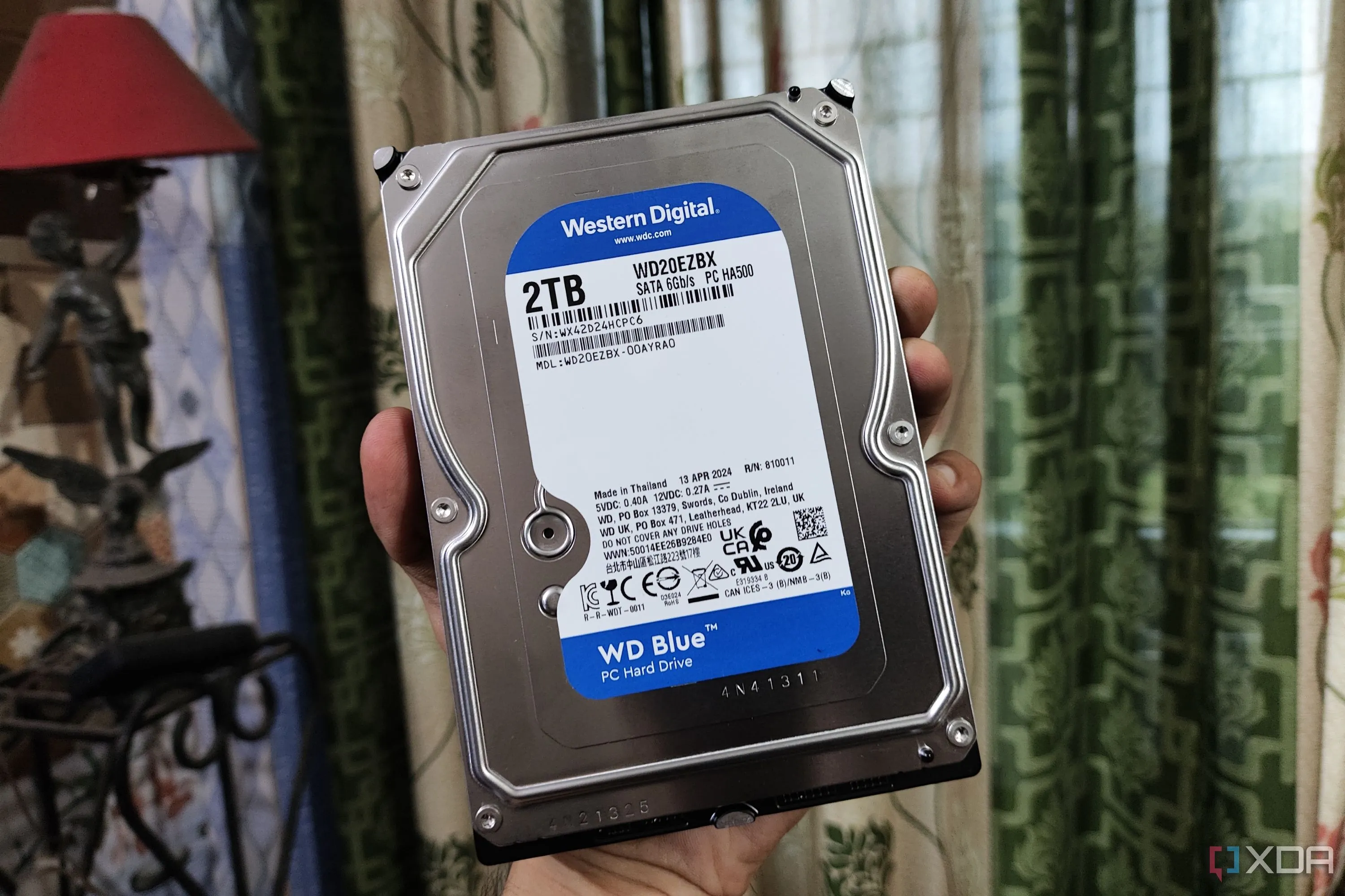 Ổ cứng HDD Western Digital Blue được giữ trên tay, gợi ý kiểm tra sức khỏe thiết bị lưu trữ cũ
