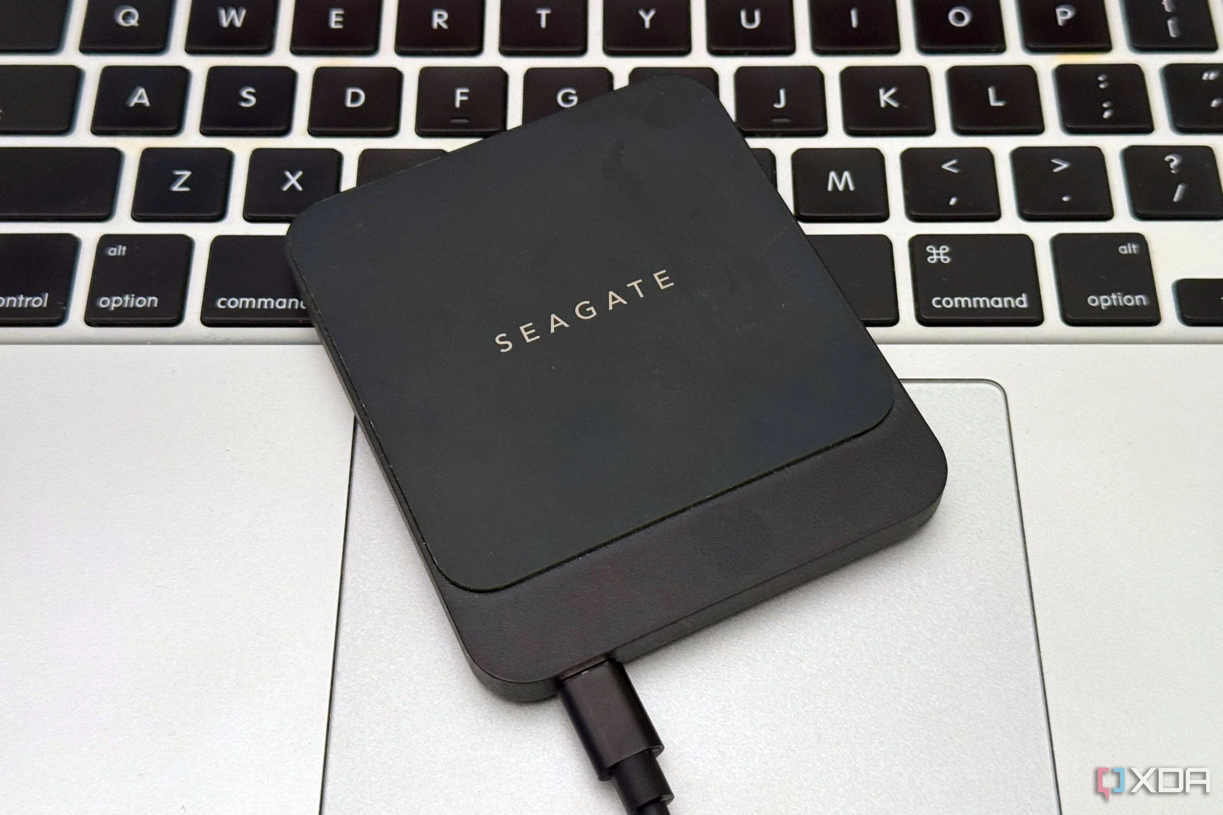 Ổ SSD gắn ngoài đặt trên bàn di chuột của MacBook