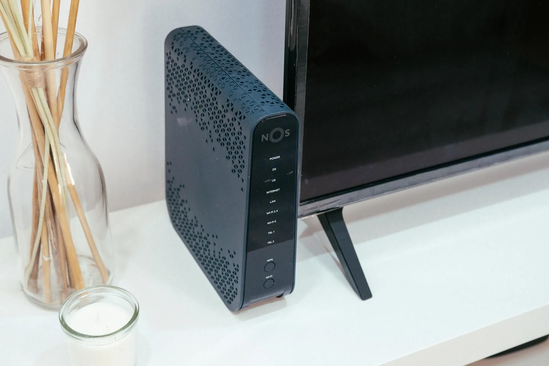 Router Wi-Fi đặt cạnh TV, tượng trưng cho việc thiết bị mạng cũ không theo kịp tốc độ Internet mới sau khi nâng cấp gói cước